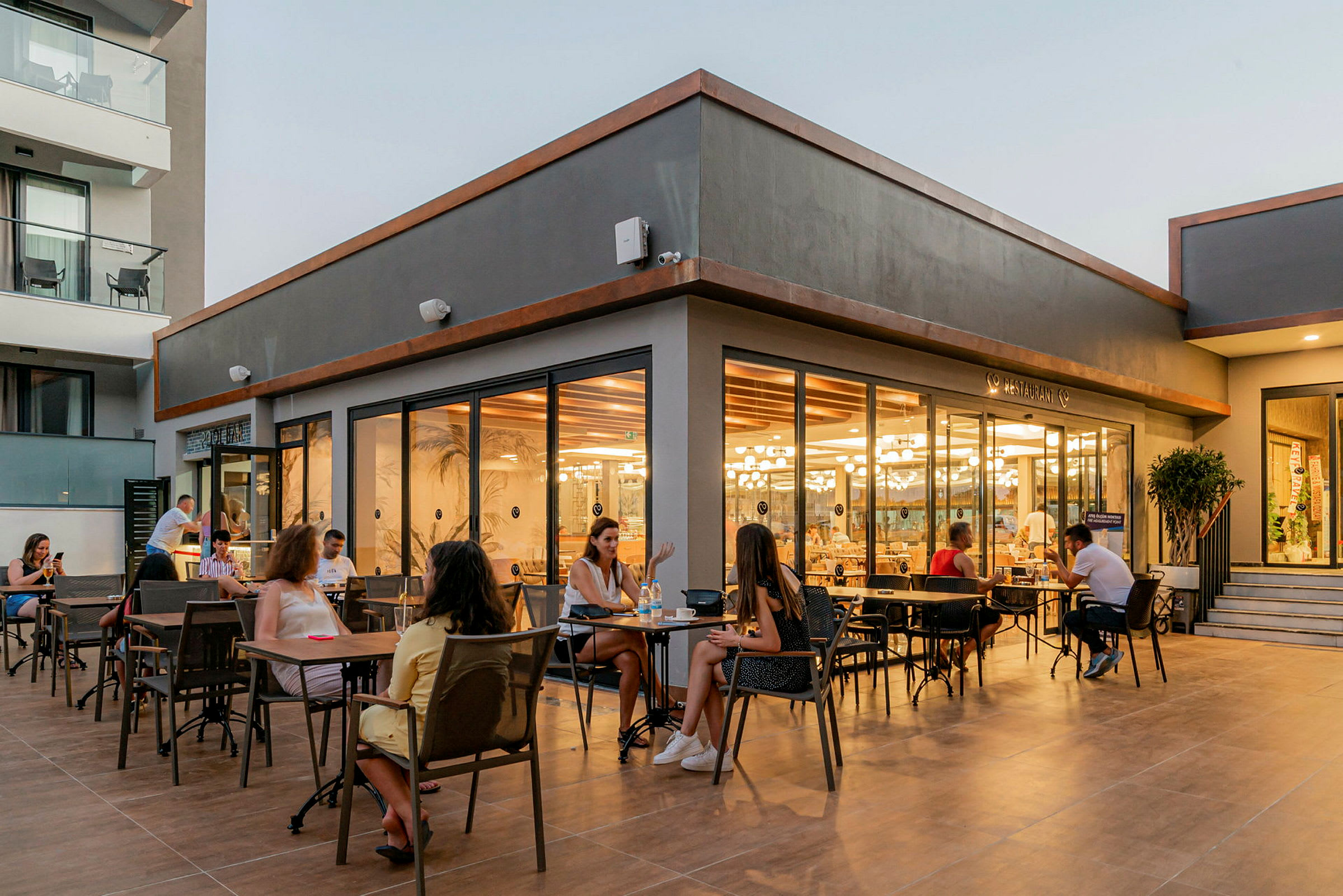 Utendørs servering med gjester på et moderne restaurantområde. (AI-generert tekst)