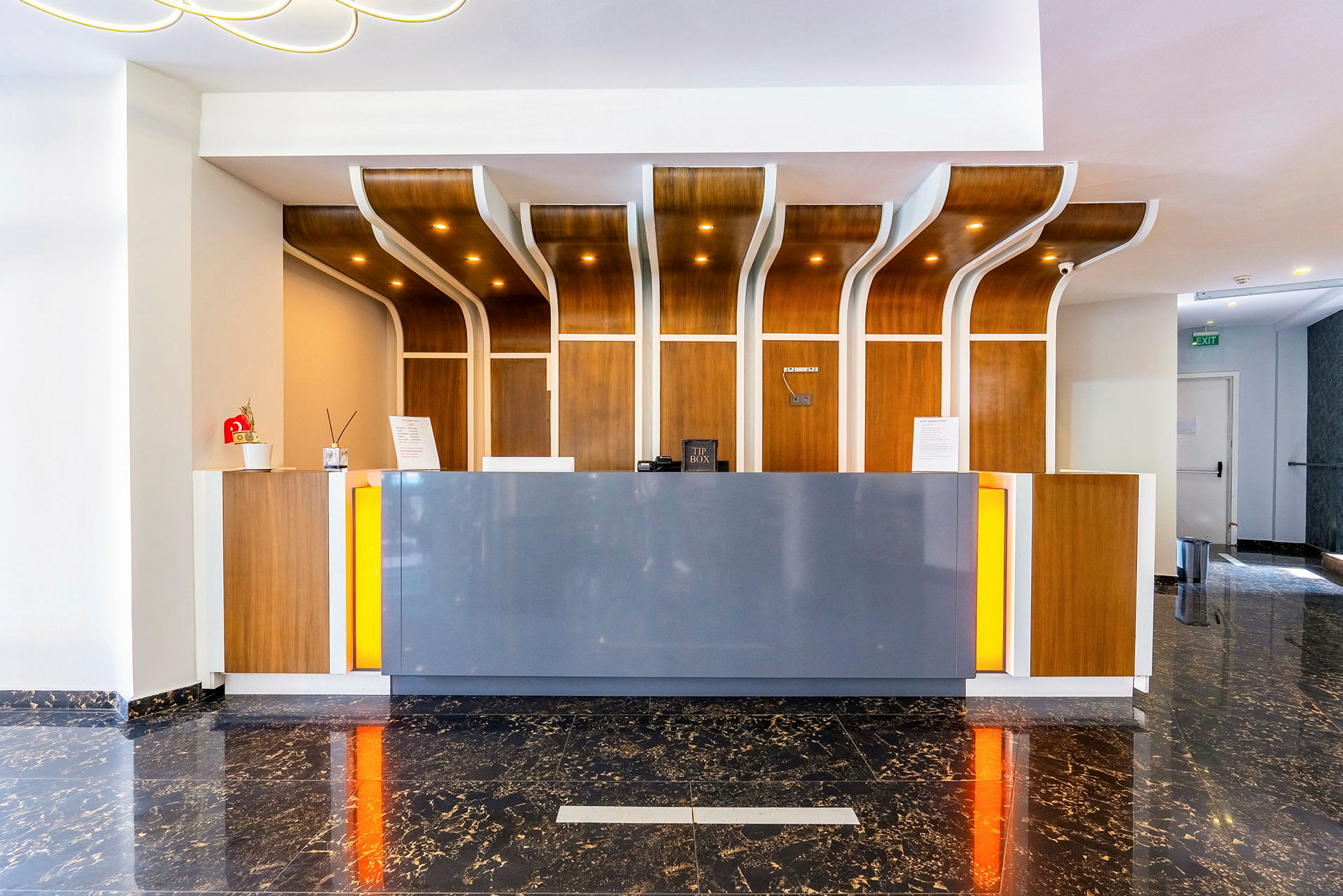 Hotellresepsjon med moderne design, tredetaljer og marmorgulv. (AI-generert tekst)