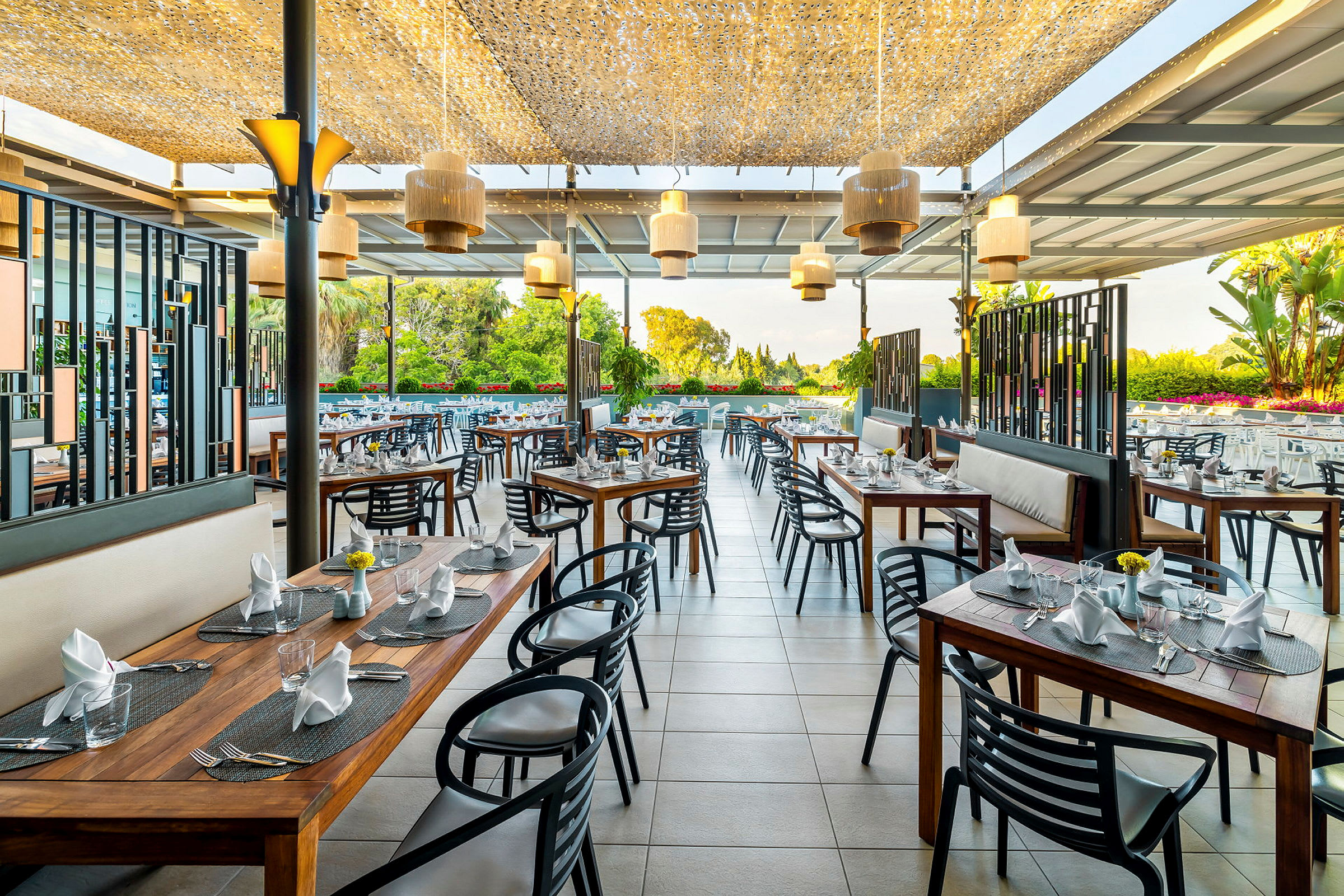 Restaurant med uteservering og moderne møbler, bord med oppdekning. (AI-generert tekst)