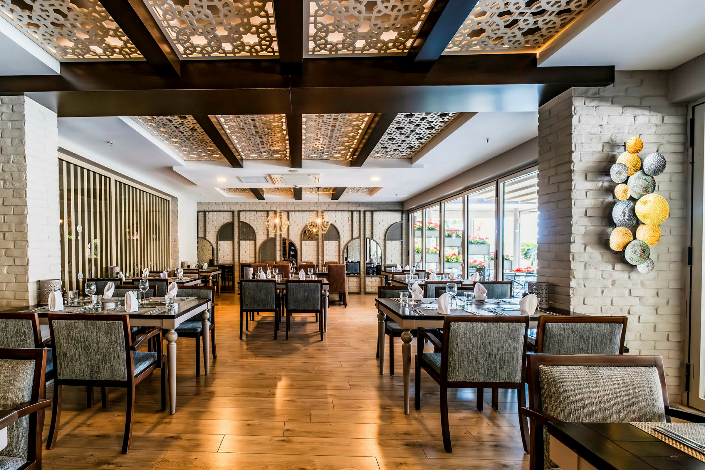 Interiør av en elegant restaurant med moderne møbler og dekorative takdetaljer. (AI-generert tekst)