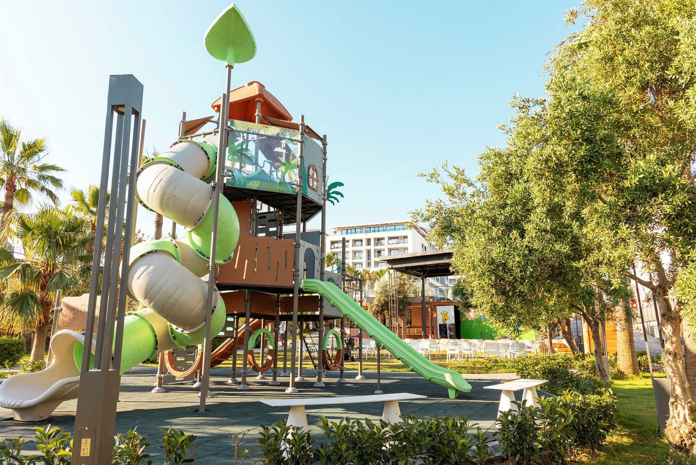 En lekeplass med klatrestativ, sklier og grøntområder. (AI-generert tekst)