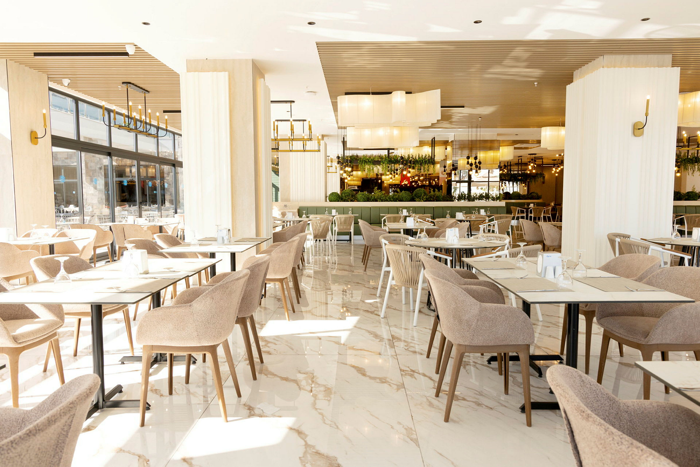 Interiør av en romslig og lys restaurant med bord og stoler. (AI-generert tekst)
