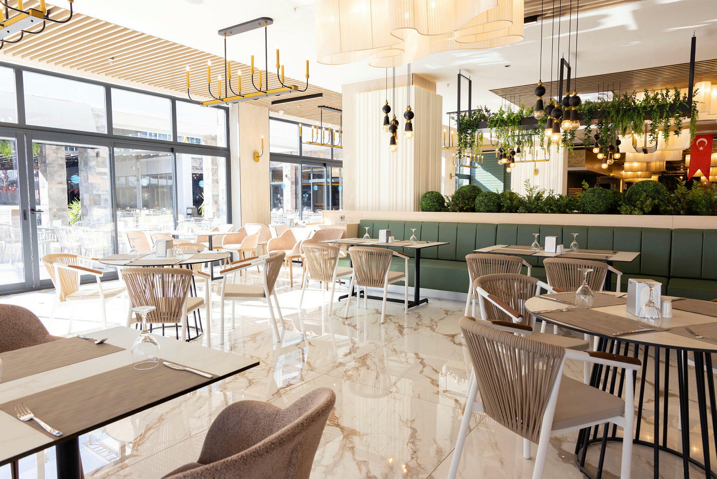 En lys og moderne restaurant med store vinduer og elegant interiør. (AI-generert tekst)