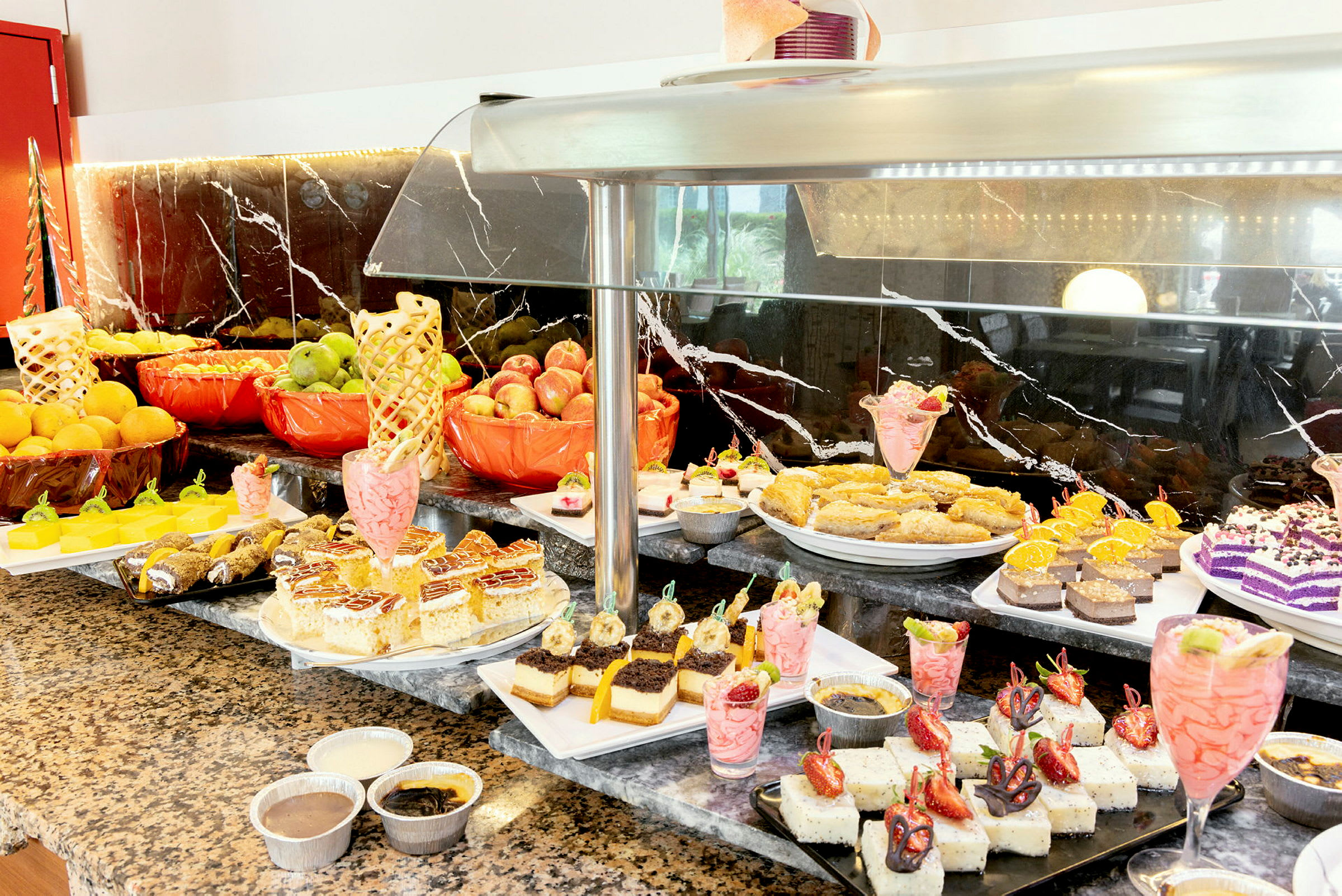 Buffet med forskjellige desserter og frisk frukt. (AI-generert tekst)