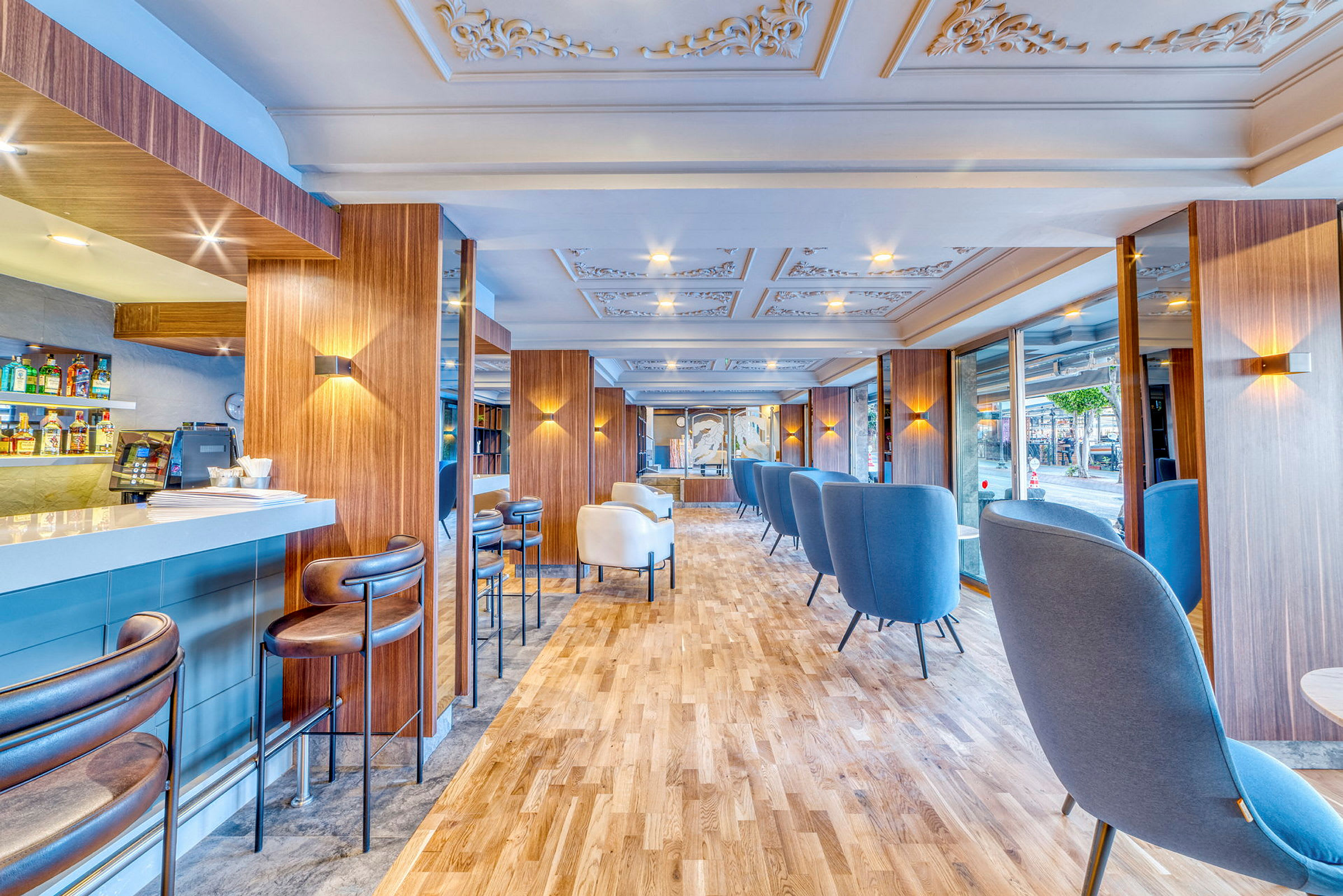 En moderne innendørs lounge med blå og hvite sittemøbler og et barområde. (AI-generert tekst)