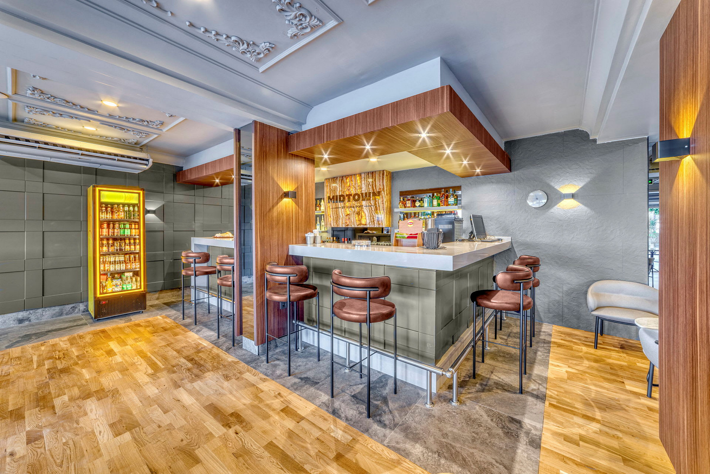 En bar med sitteplasser og en drikkekjøler ved siden av. (AI-generert tekst)