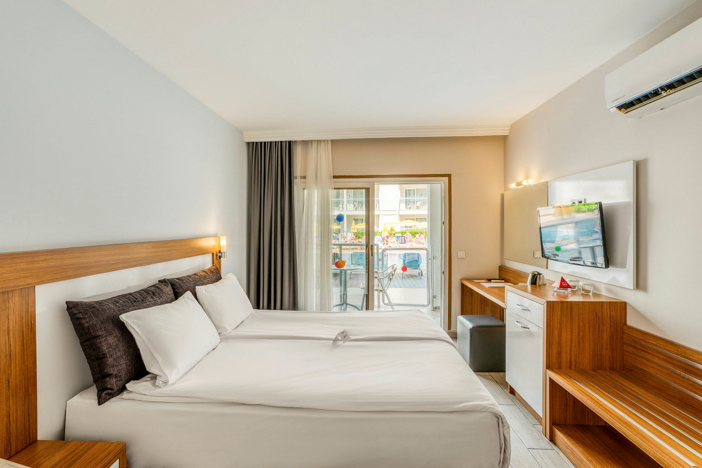 Hotellrom med dobbeltseng og balkong. (AI-generert tekst)
