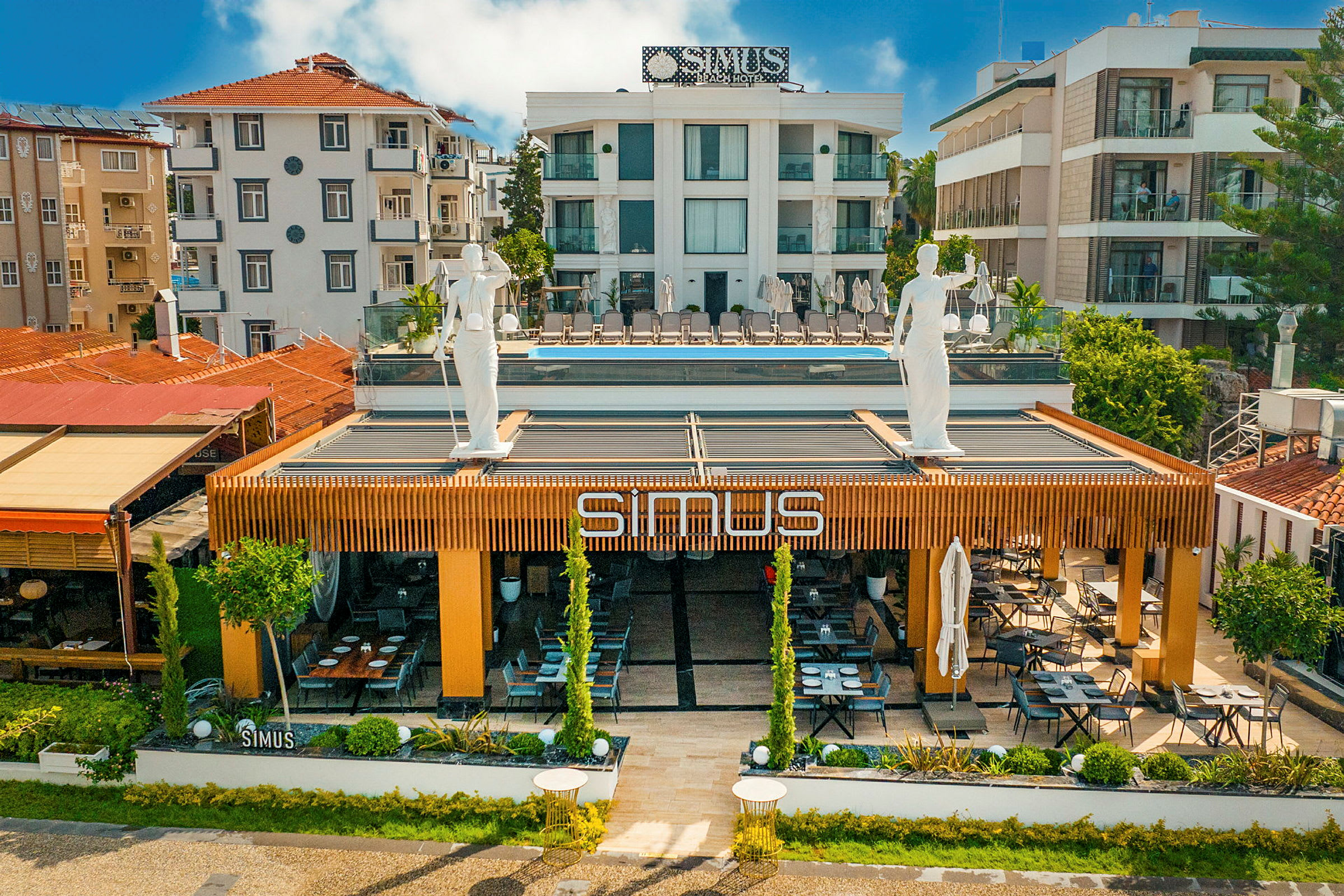 Fasaden av en bygning med en restaurant med navnet "SIMUS". (AI-generert tekst)