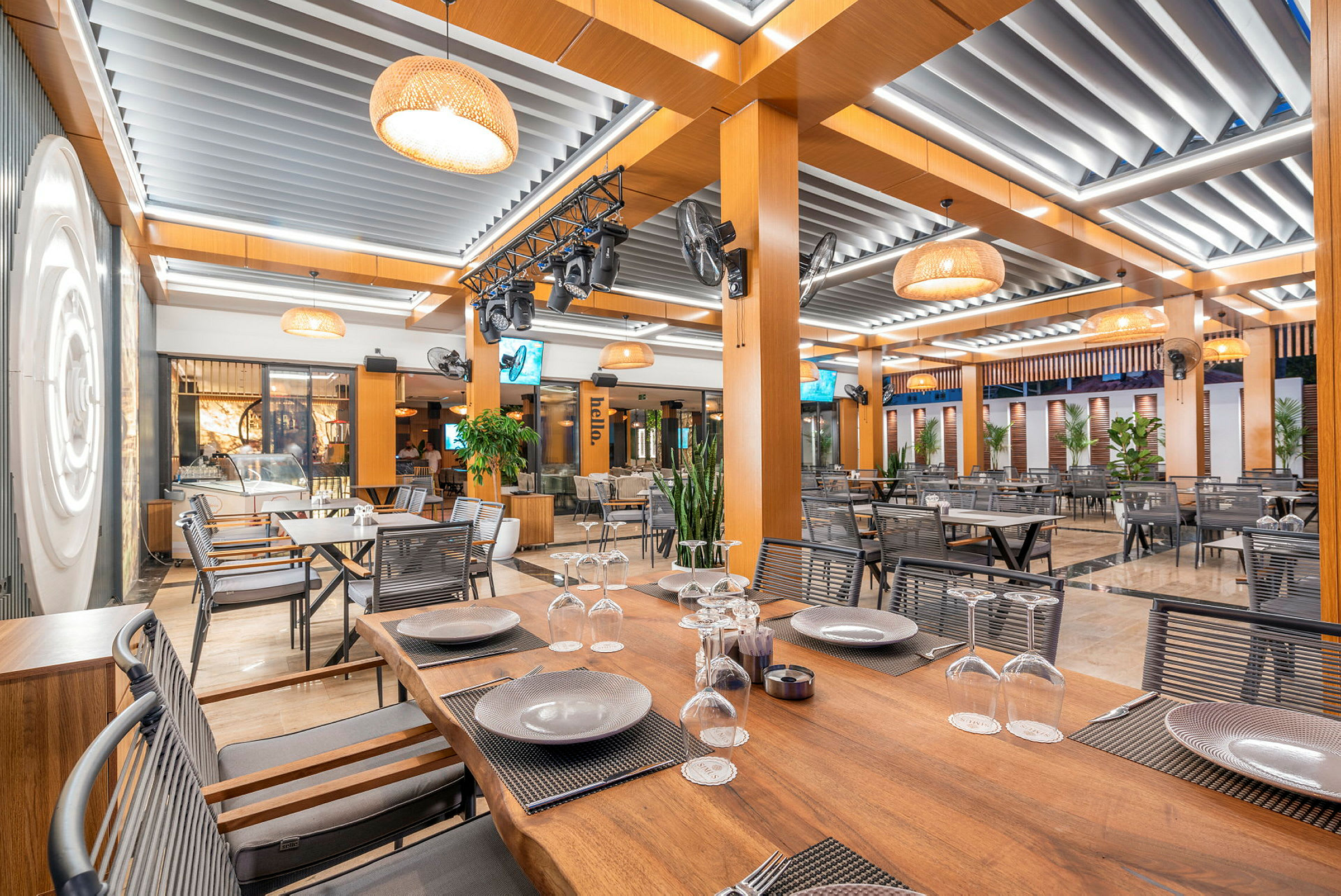 Innendørsområde i en moderne restaurant med trebord og takdekor. (AI-generert tekst)