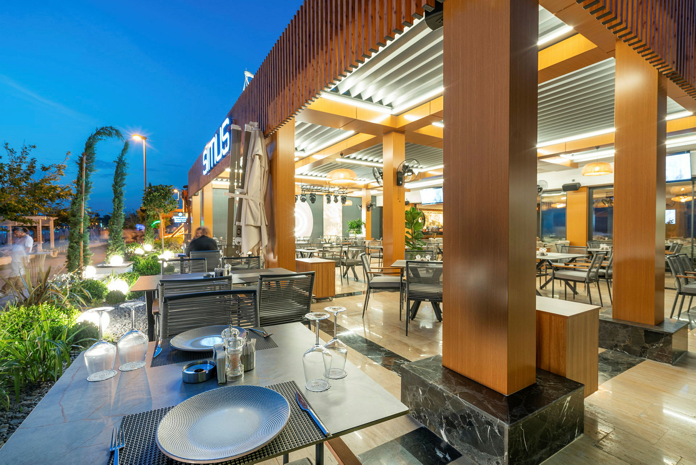 Bilde av en moderne restaurant med uteplass om kvelden. (AI-generert tekst)