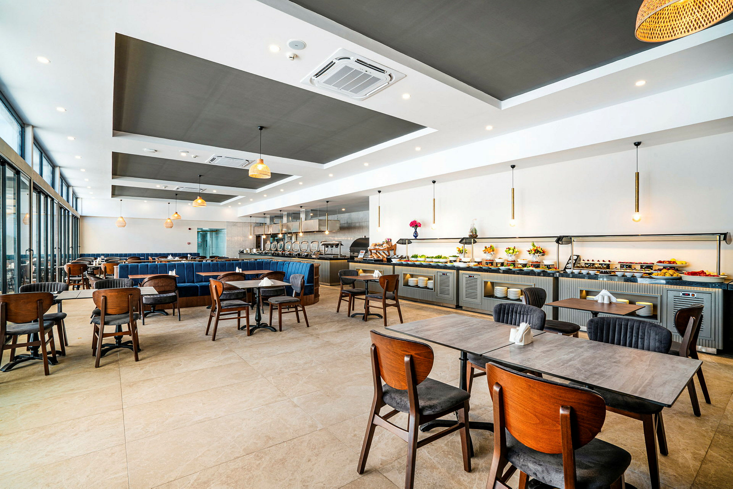 En romslig restaurant med bord og stoler samt en buffédisk langs veggen. (AI-generert tekst)