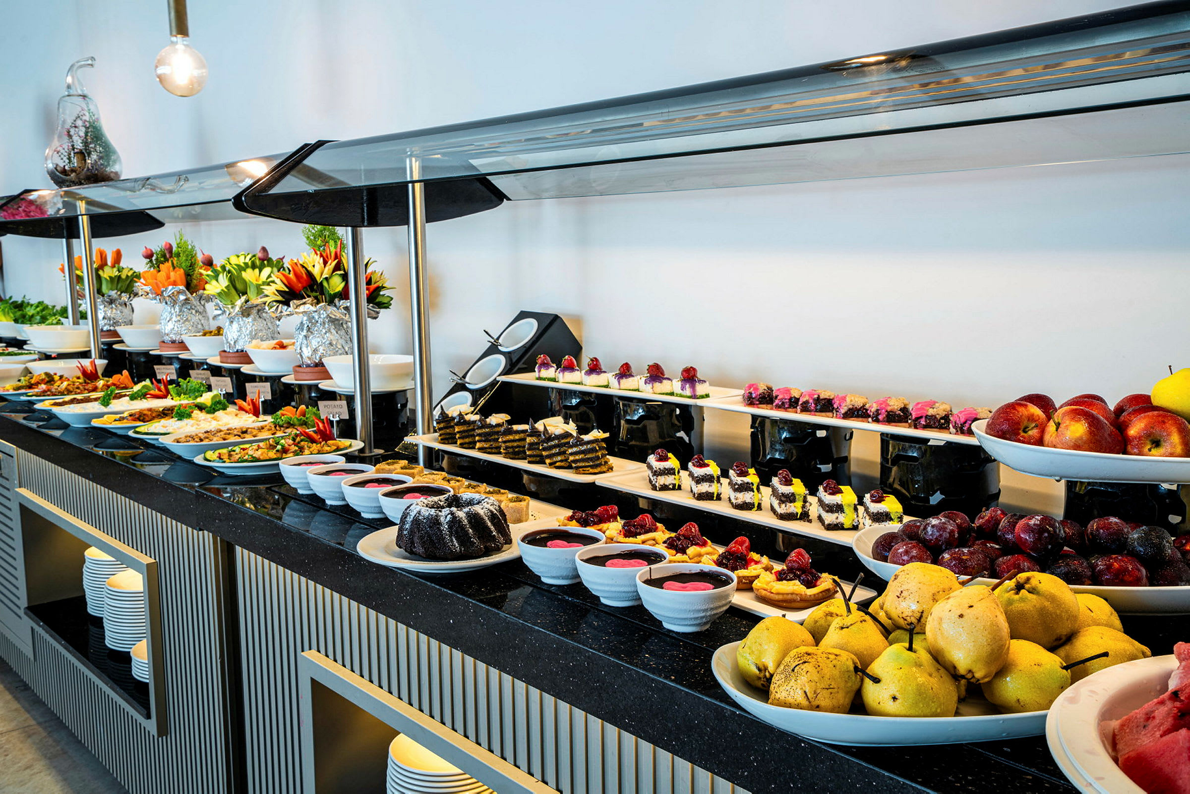 Buffetbord med et utvalg av frukt, desserter og varme retter. (AI-generert tekst)