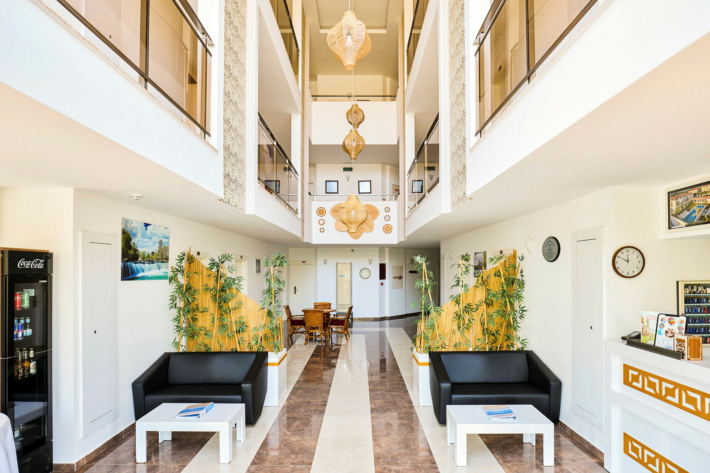 Interiør av en hotellobby med sofaer, bord og dekorasjoner. (AI-generert tekst)