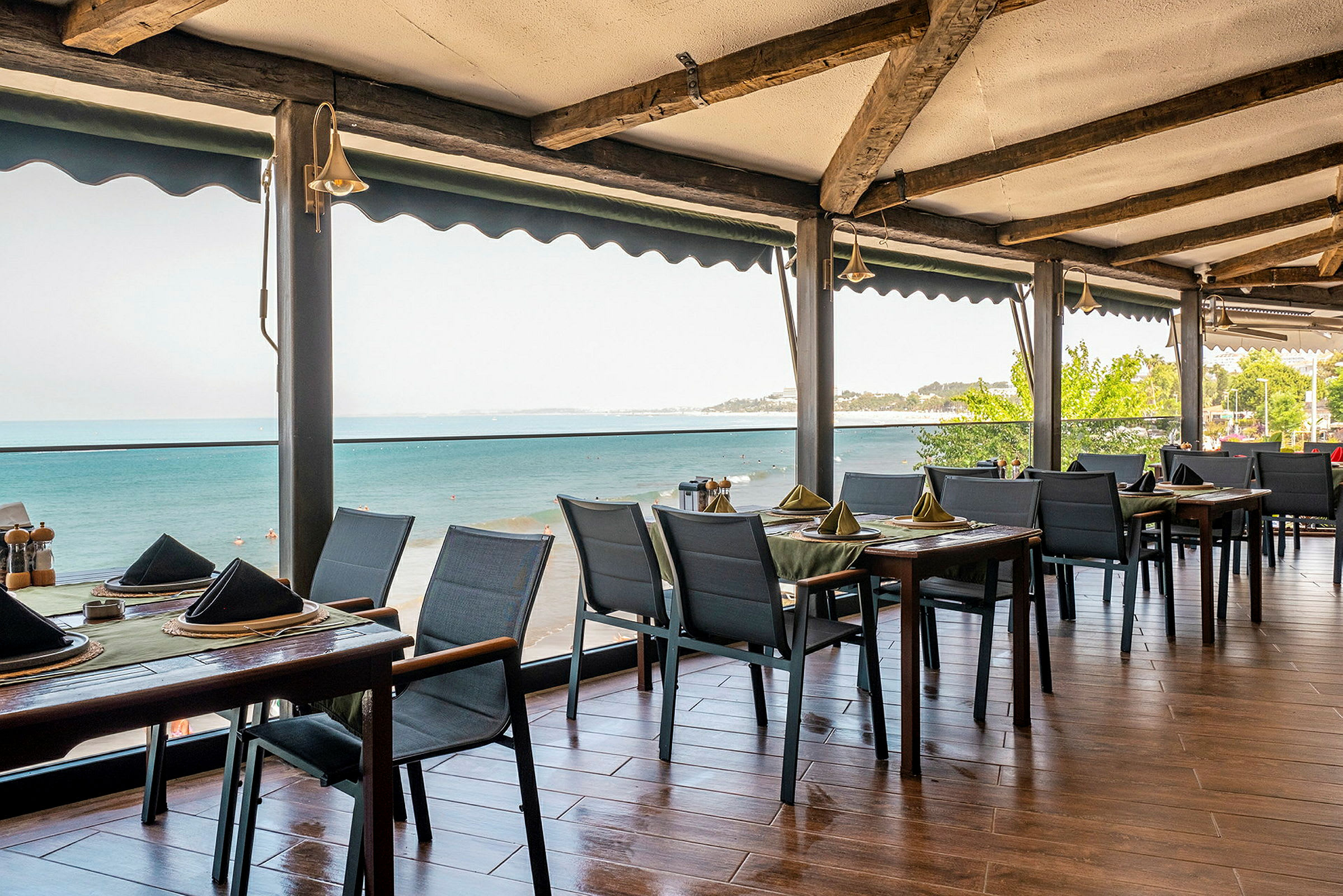 Restaurantbord med borddekking og utsikt over havet. (AI-generert tekst)