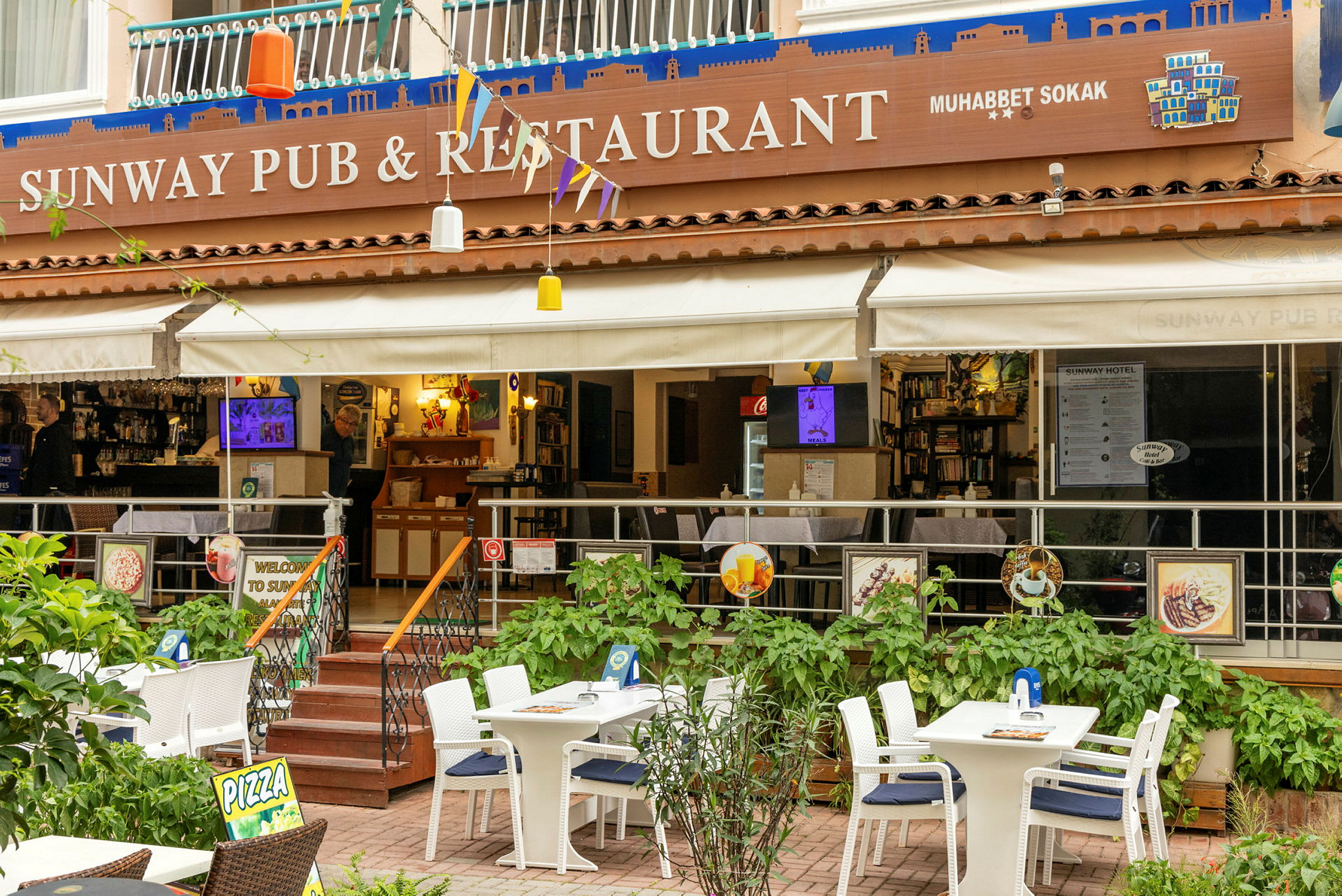 En utendørs terrasse av en restaurant med bord og stoler. (AI-generert tekst)
