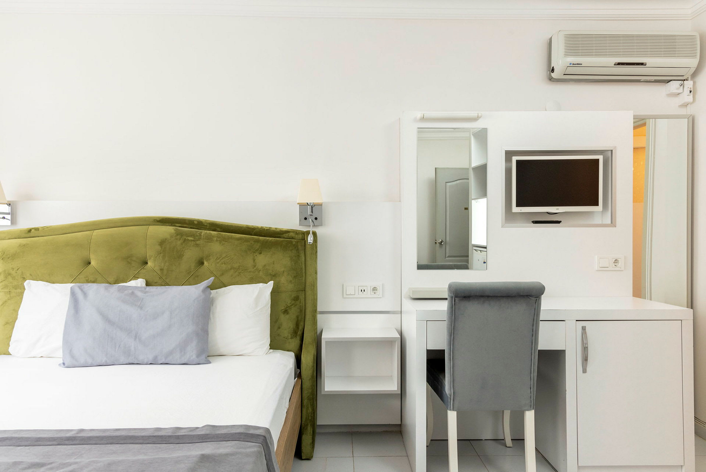 Hotellrom med en seng og skrivebord med stol. (AI-generert tekst)