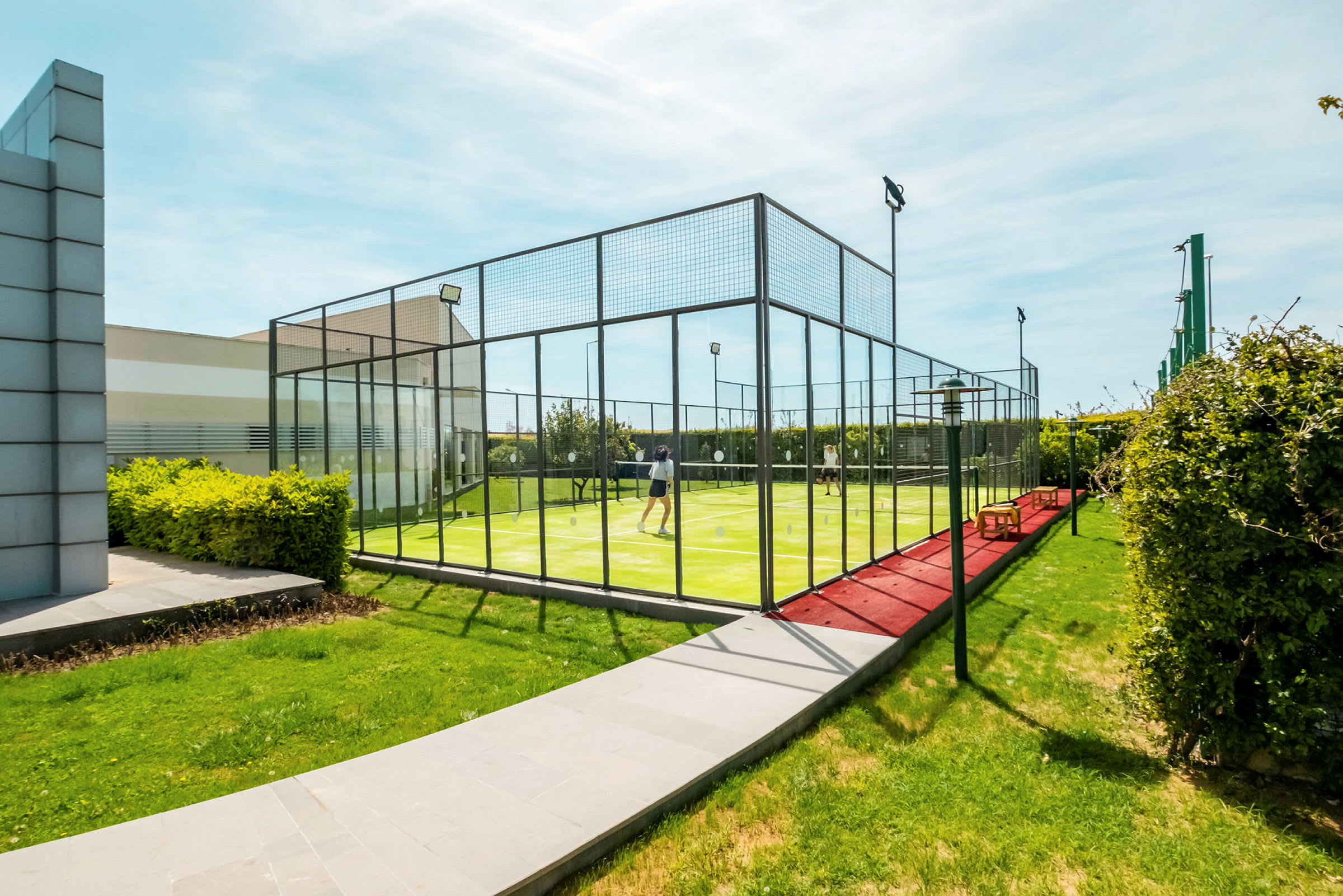 Personer spiller padel på en utendørs bane. (AI-generert tekst)