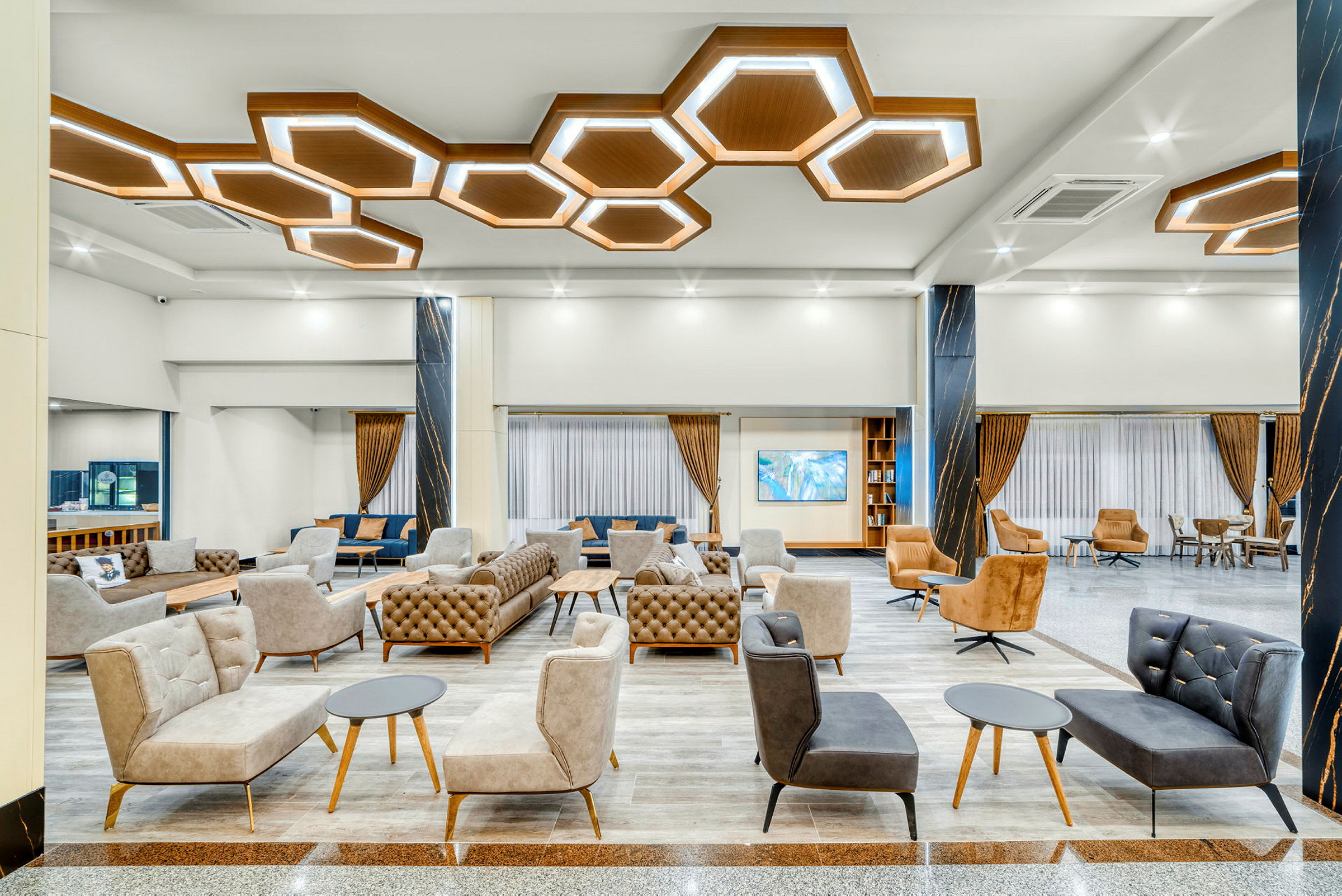 Moderne hotellobby med elegante sittemøbler og geometriske taklamper. (AI-generert tekst)
