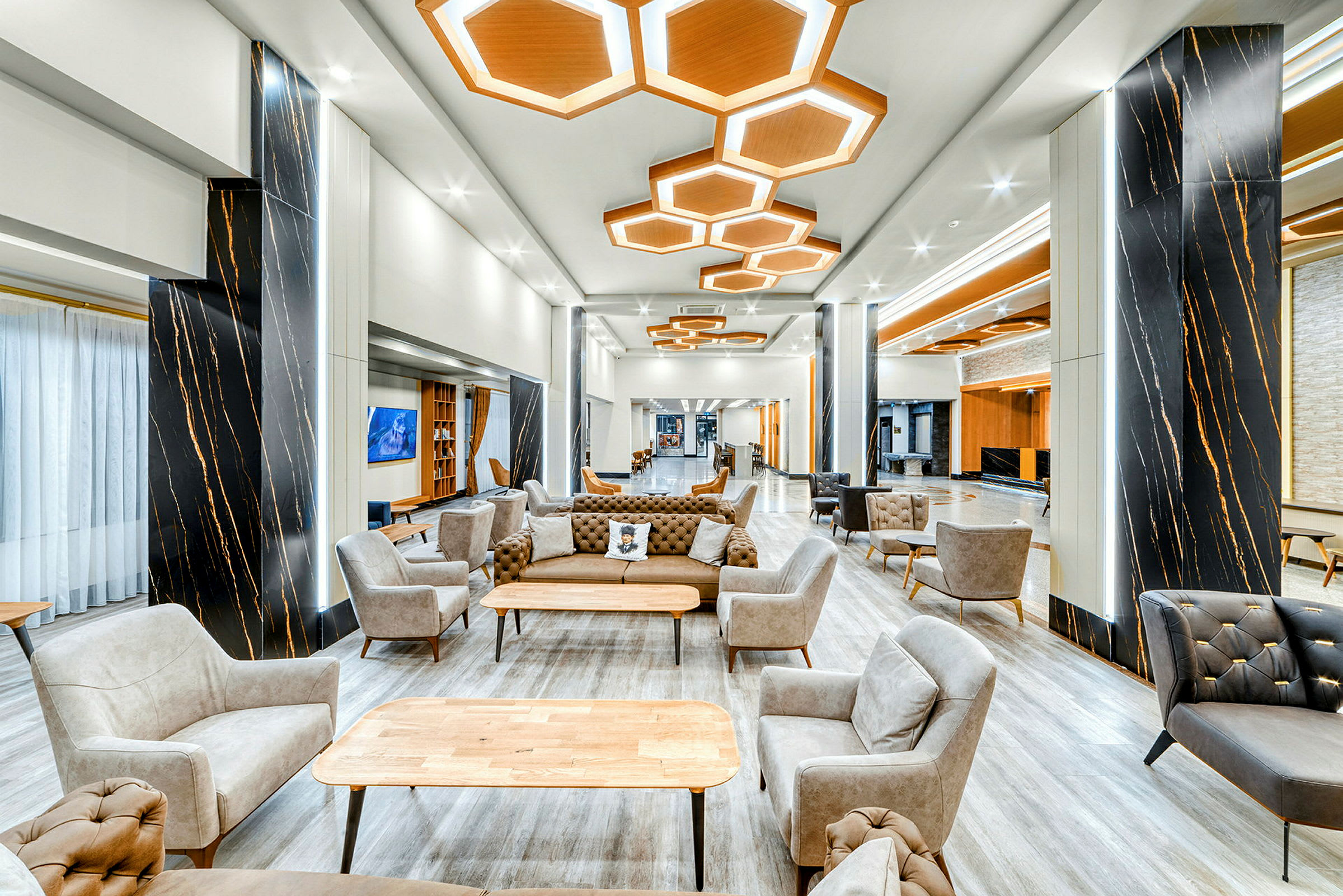 En moderne og godt opplyst lounge med stoler og sofaer foran et bord. (AI-generert tekst)