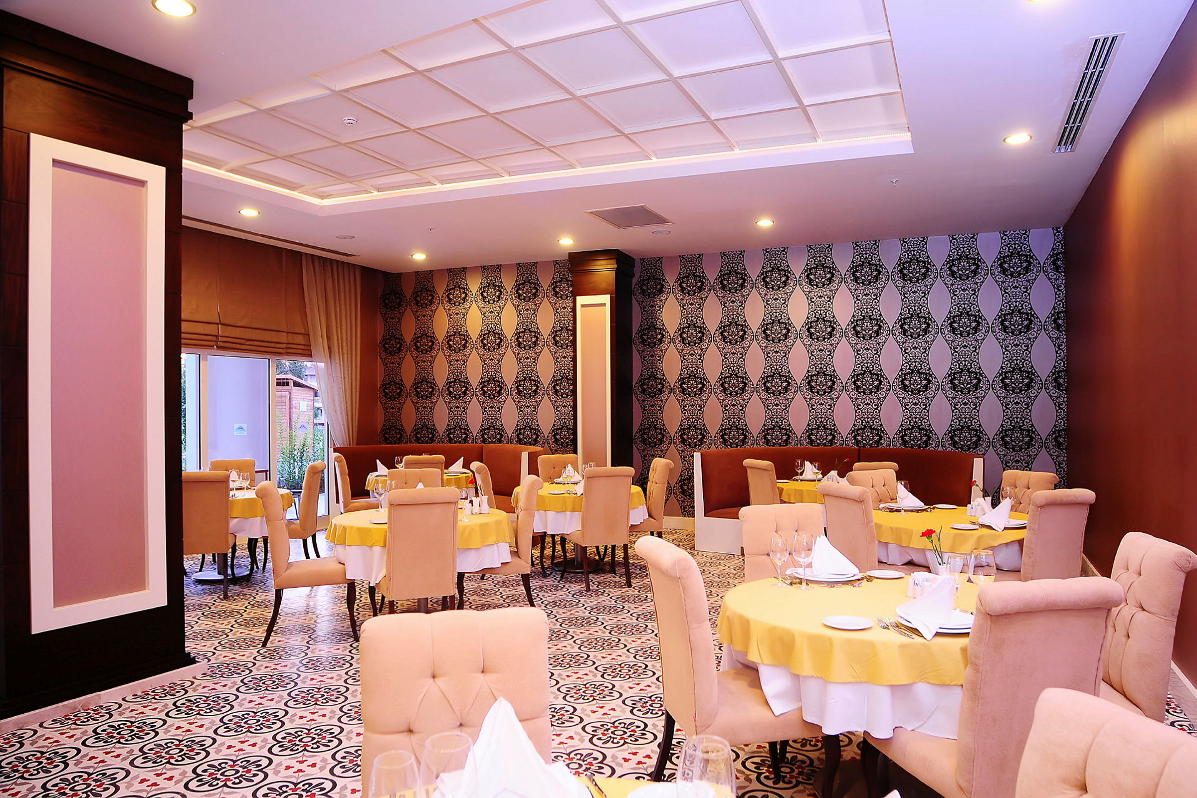 Restaurant med borddekking og dekorerte vegger. (AI-generert tekst)