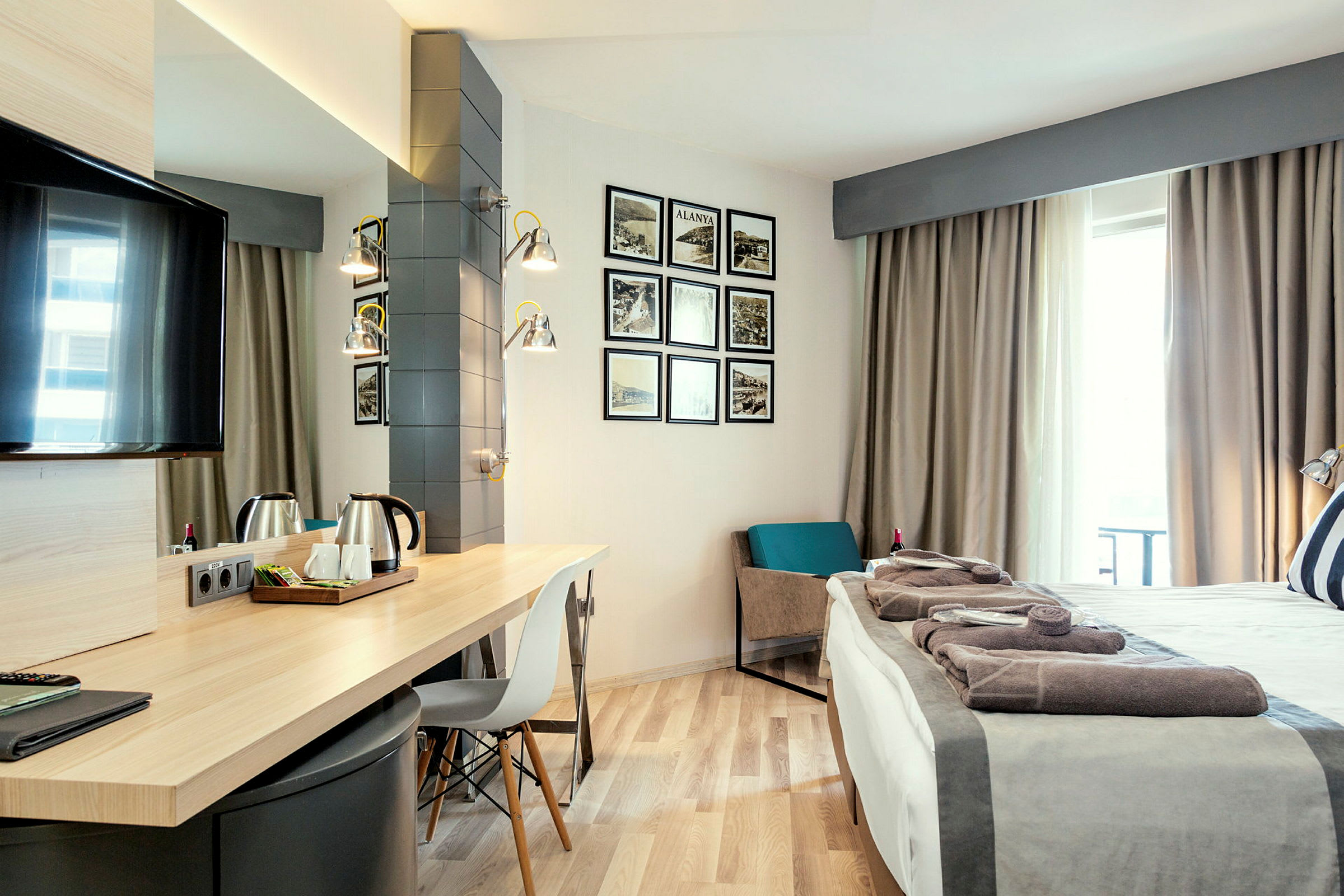 Hotellrom med skrivebord, seng og dekorasjoner på veggen. (AI-generert tekst)