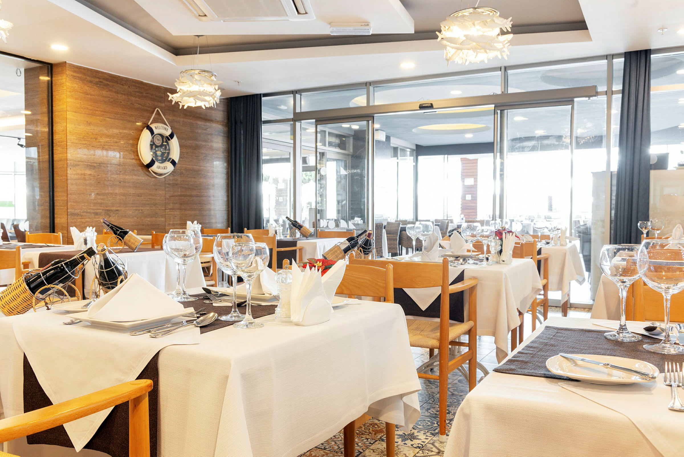 En restaurant med dekkede bord og trestoler. (AI-generert tekst)