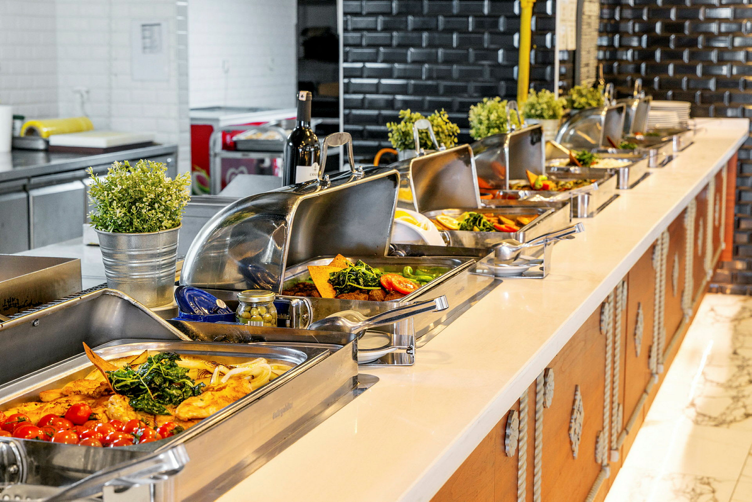 Buffetbord med ulike retter servert i rustfrie beholdere. (AI-generert tekst)