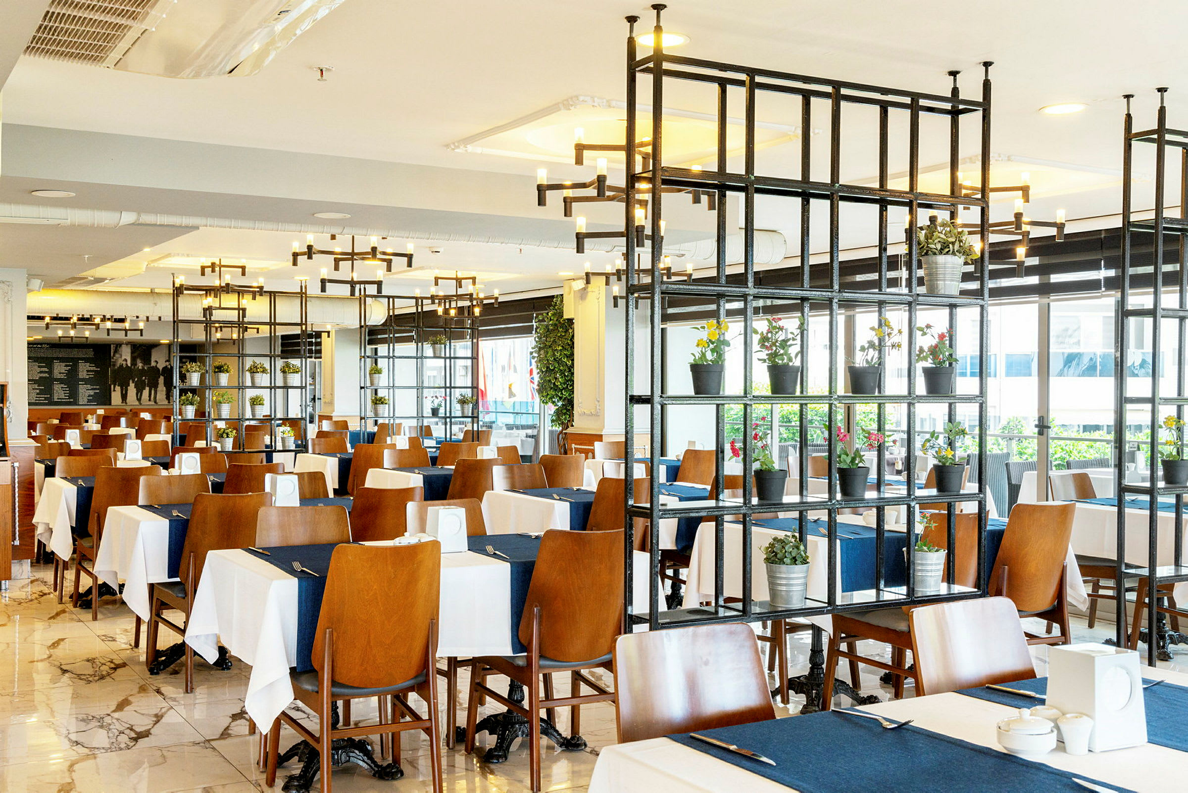 Restaurant med bord dekket med hvite og blå duker. (AI-generert tekst)