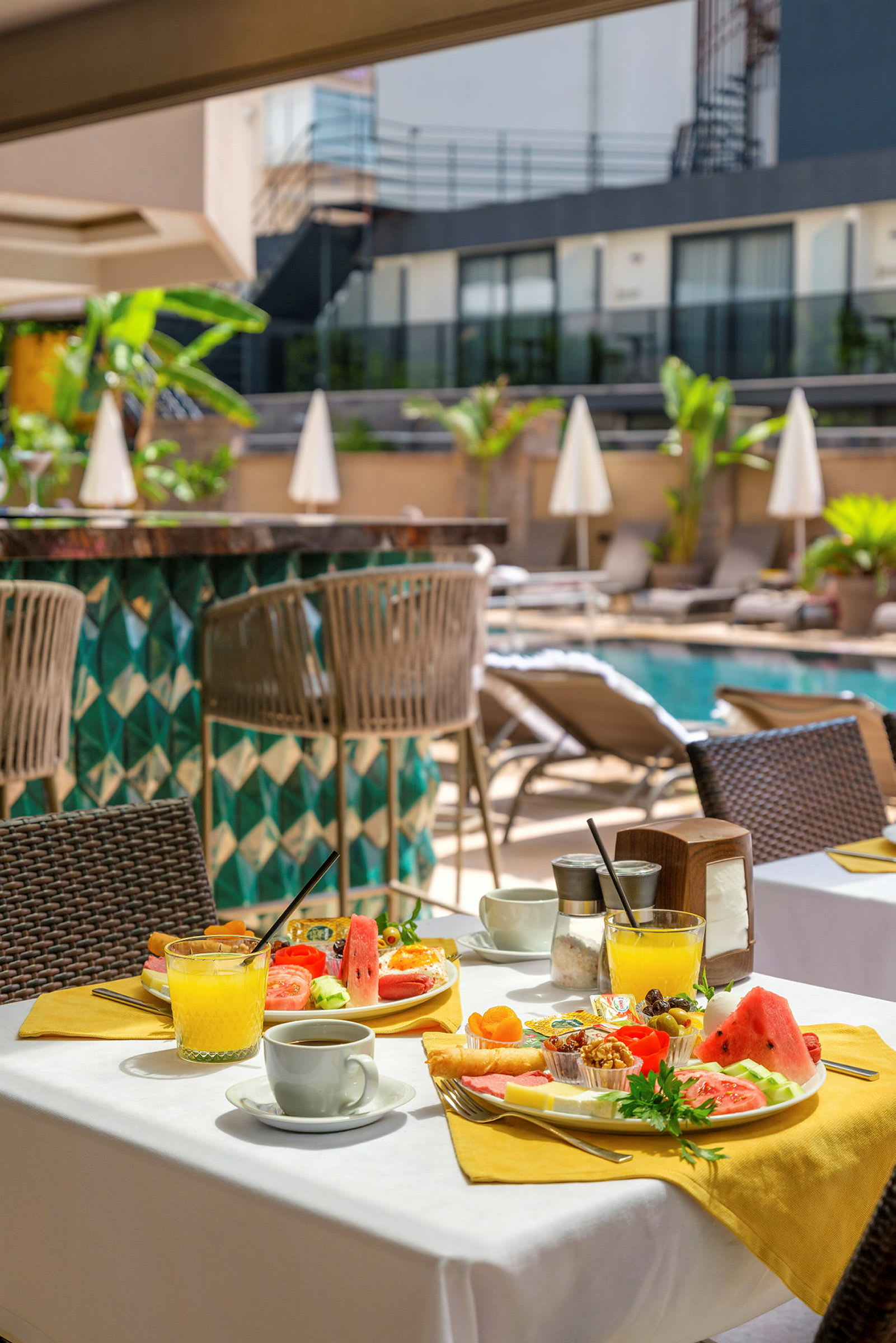 En oppdekket hotellfrokost ved bassengområdet. (AI-generert tekst)