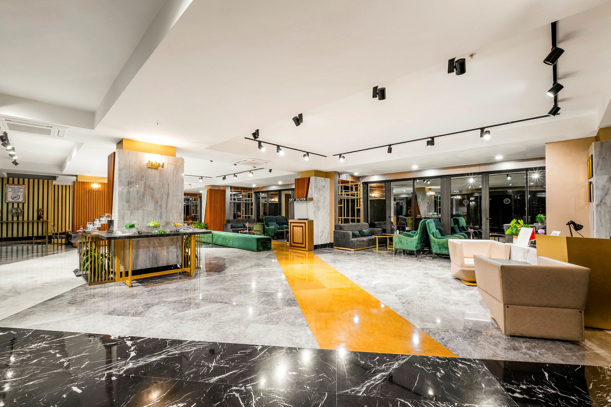 En elegant hotellobby med moderne innredning, marmorgulv og komfortable sittegrupper. (AI-generert tekst)