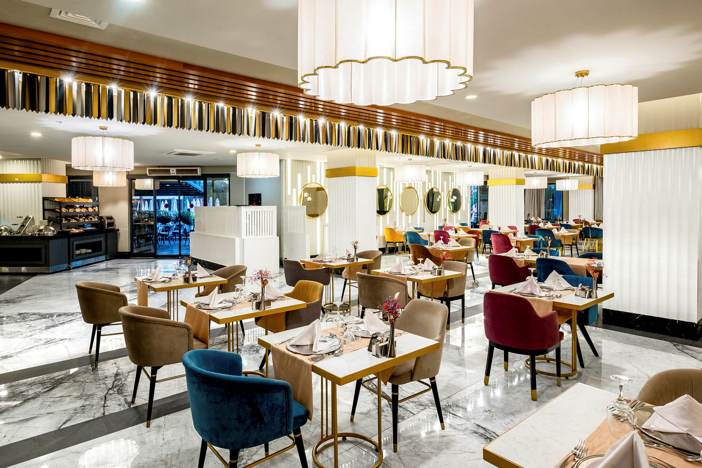 En lys og elegant restaurant med marmorgulv, dekkede bord og fargerike stoler. (AI-generert tekst)
