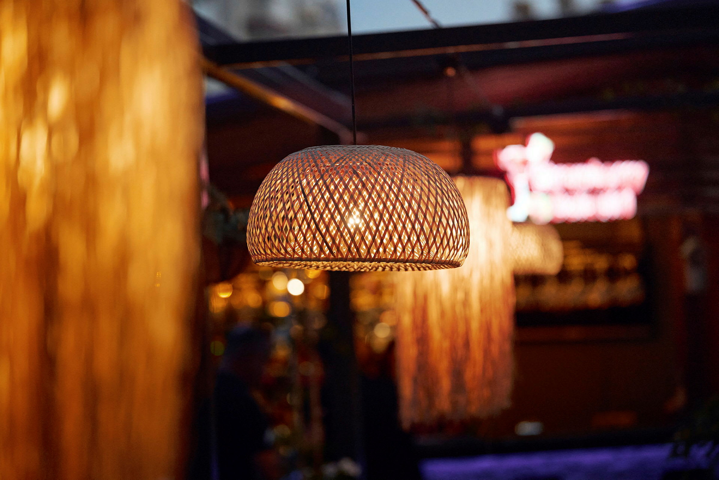 Flettet lampeskjerm med varmt lys på en restaurant. (AI-generert tekst)