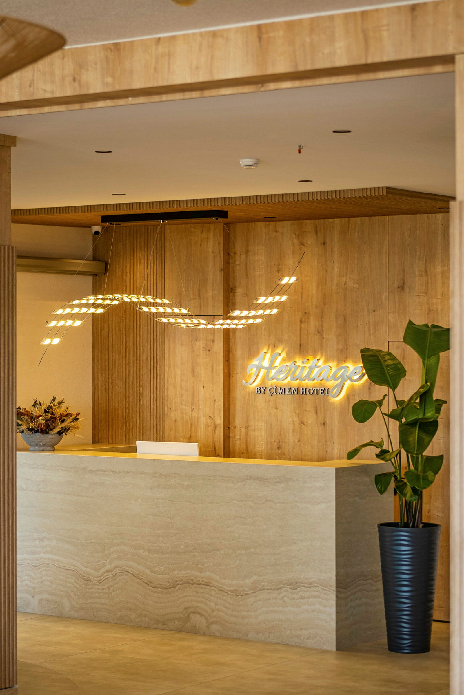 Hotellobby med resepsjonsdisk, vegg med trepanel og dekorasjoner. (AI-generert tekst)