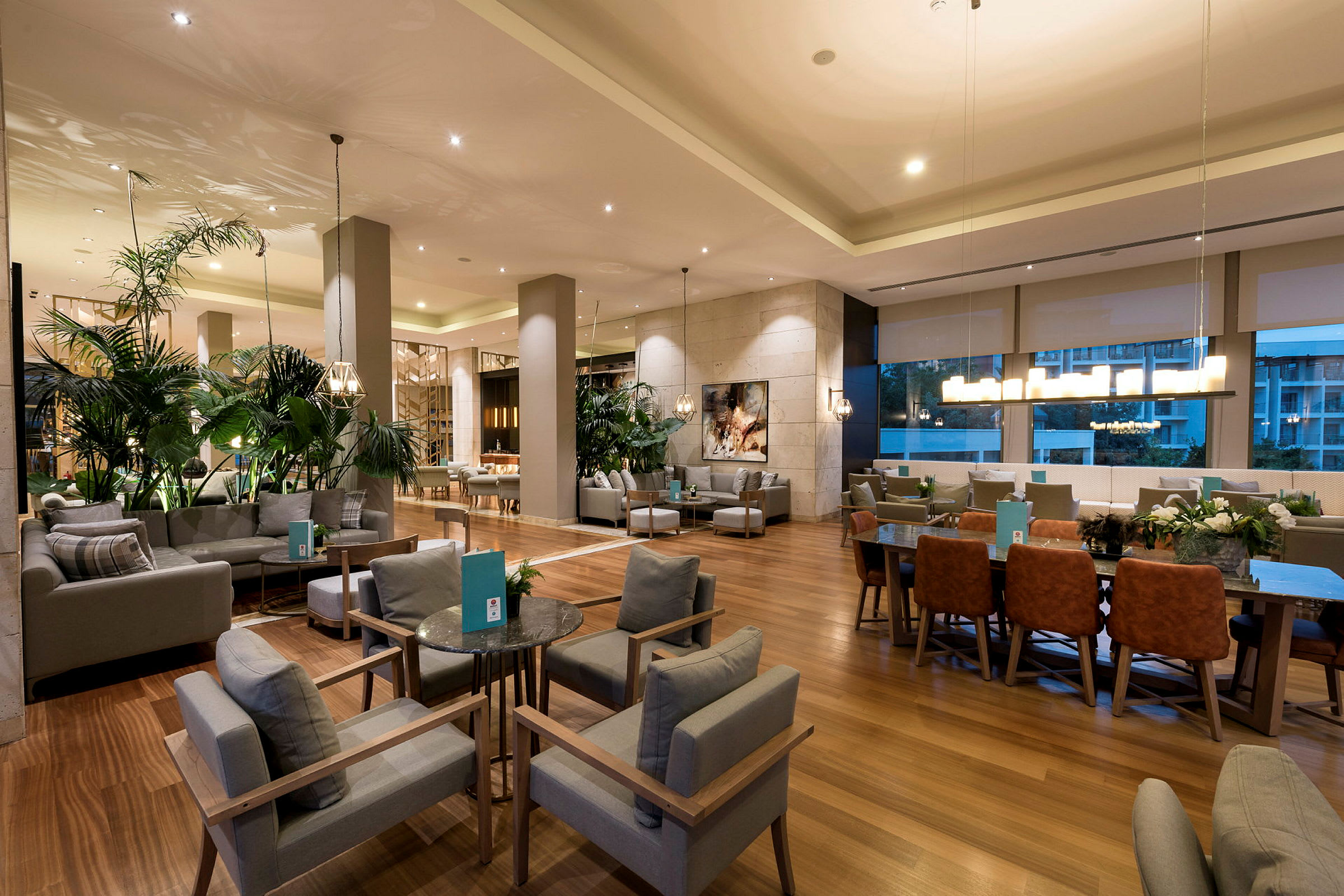 Et moderne hotelloungeområde med sitteplasser og planter. (AI-generert tekst)