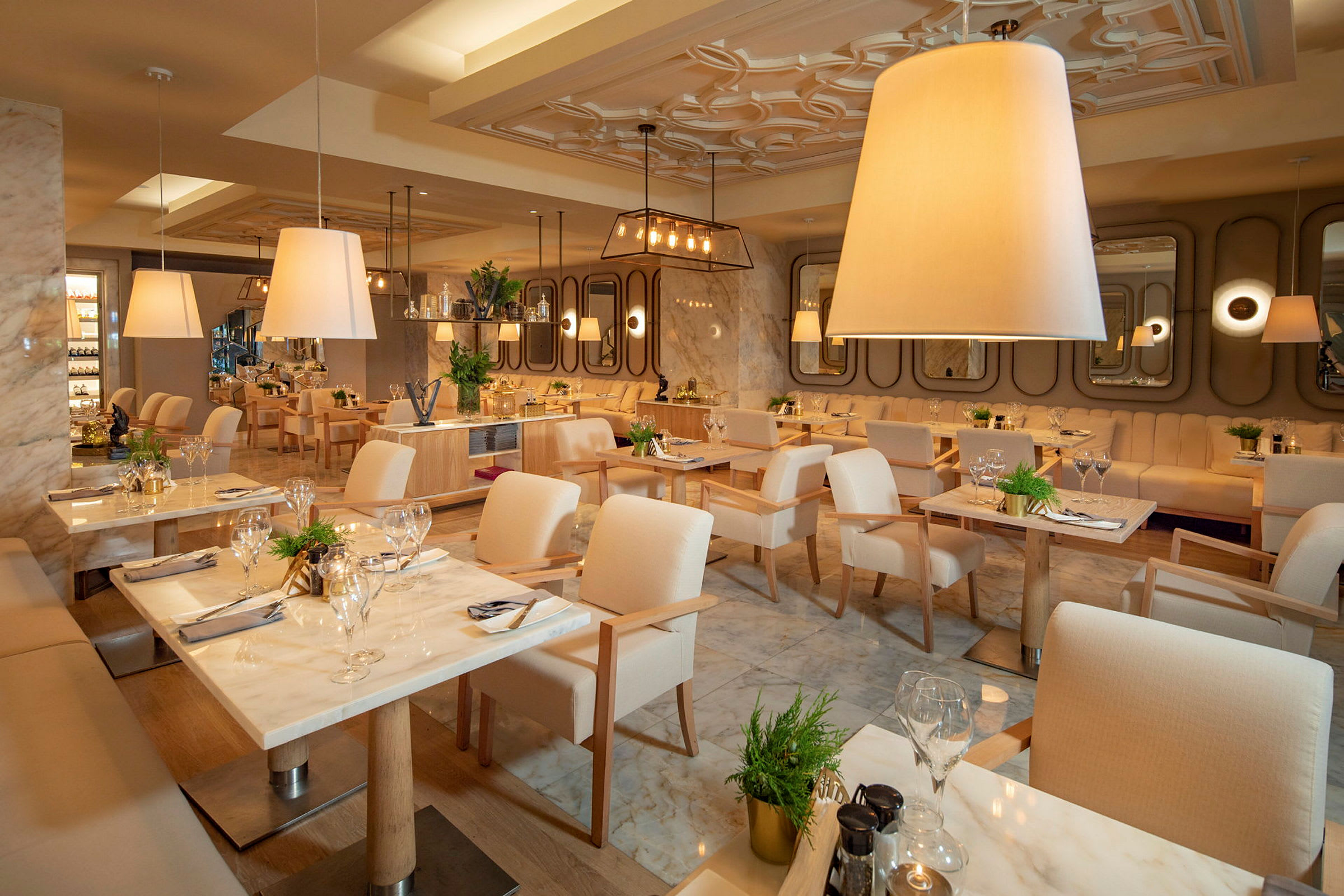 Bilde av en elegant restaurant med lyse møbler og borddekorasjoner. (AI-generert tekst)