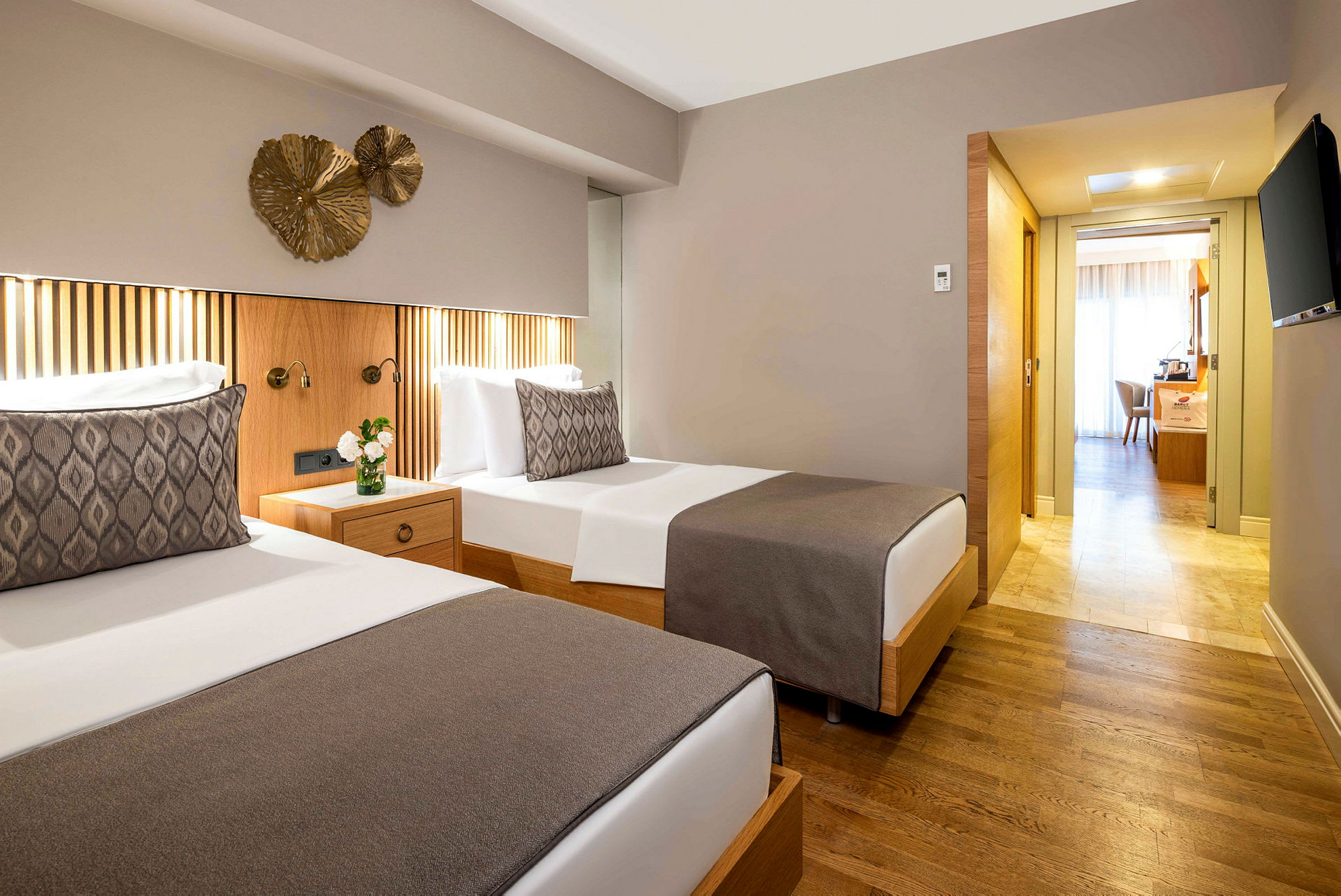 To enkeltsenger med nøytral sengeteppe i et hotellrom med tregulv og moderne interiør. (AI-generert tekst)
