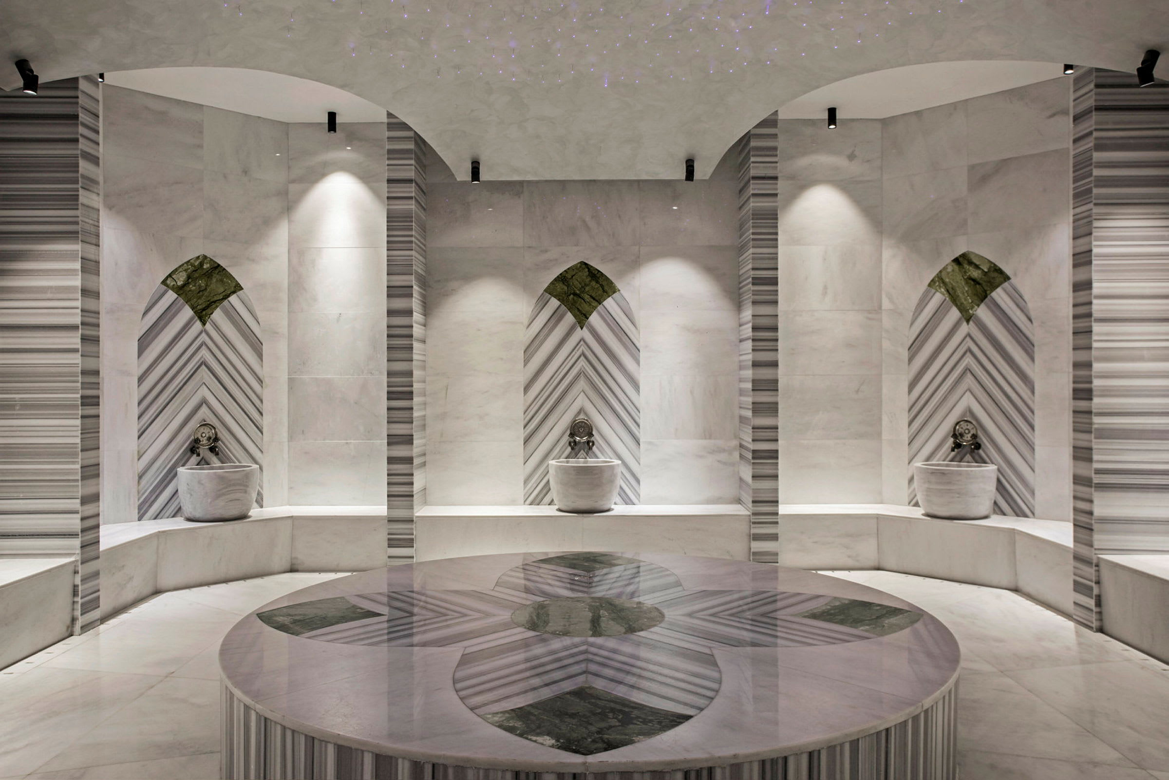 Bilde av et elegant hamam med marmorovertflater og en sentral avsats. (AI-generert tekst)