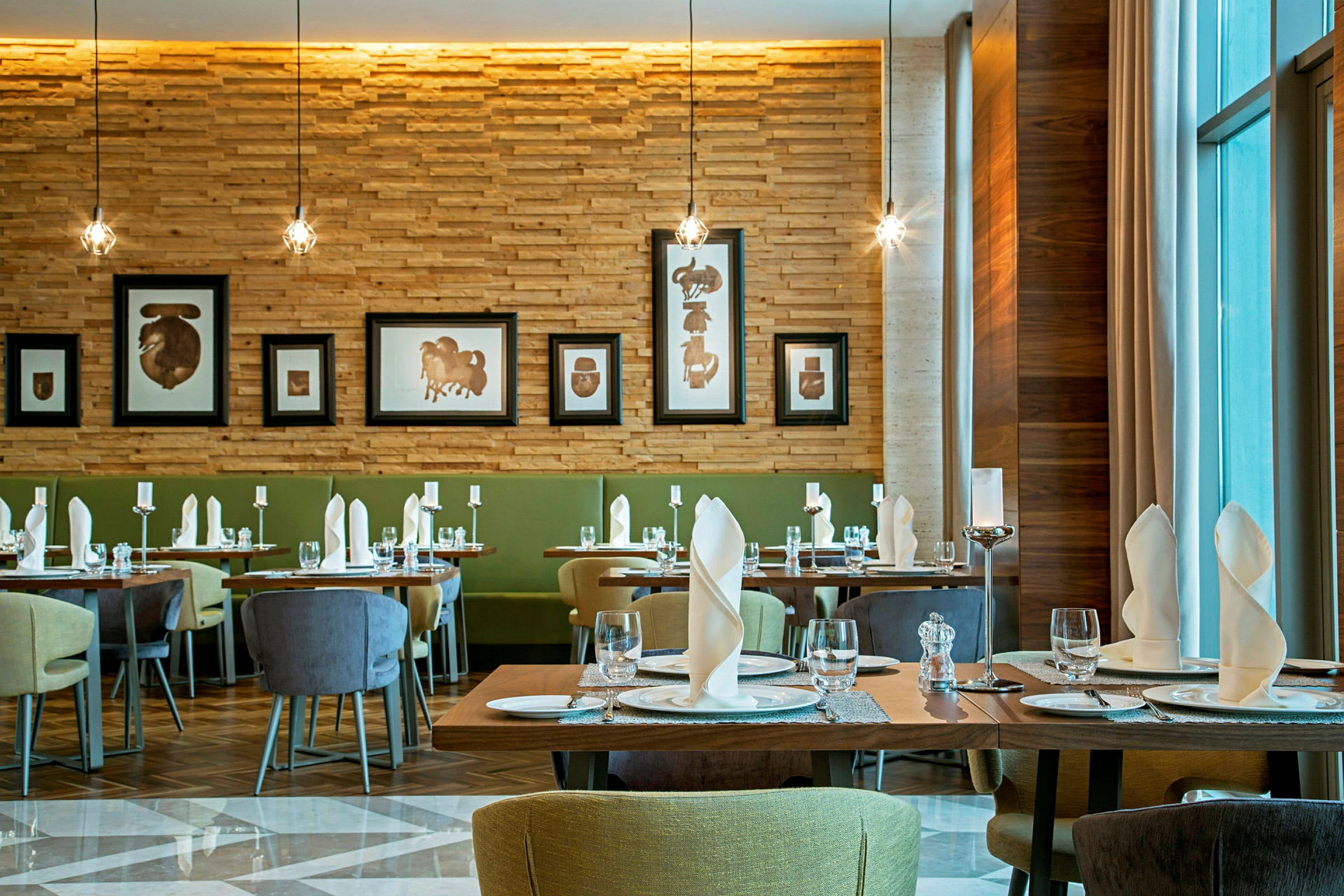 Elegant restaurant med dekkede bord, kunstverk på veggene og moderne interiør. (AI-generert tekst)