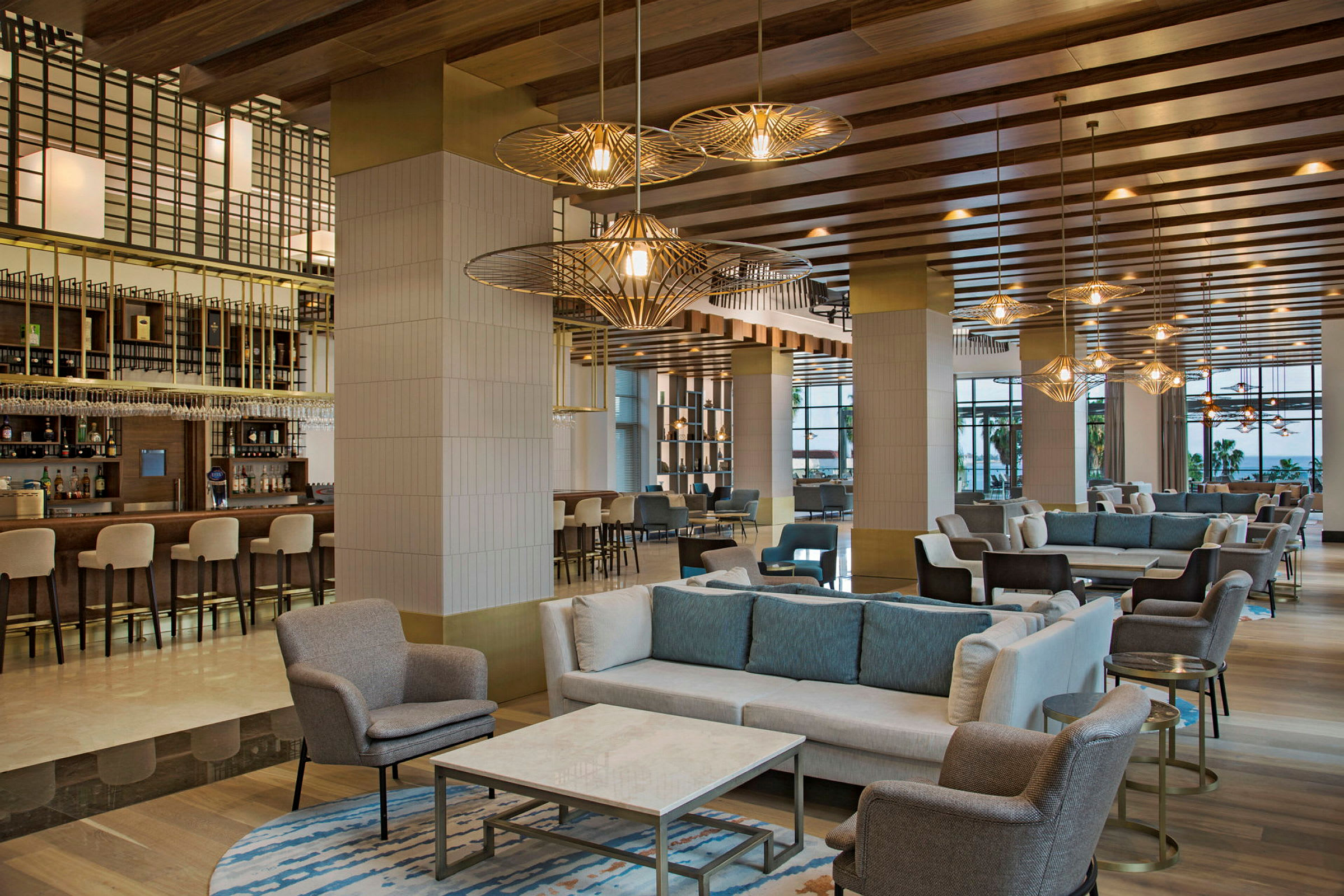 En hotellobby med komfortable sittegrupper og en bar. (AI-generert tekst)
