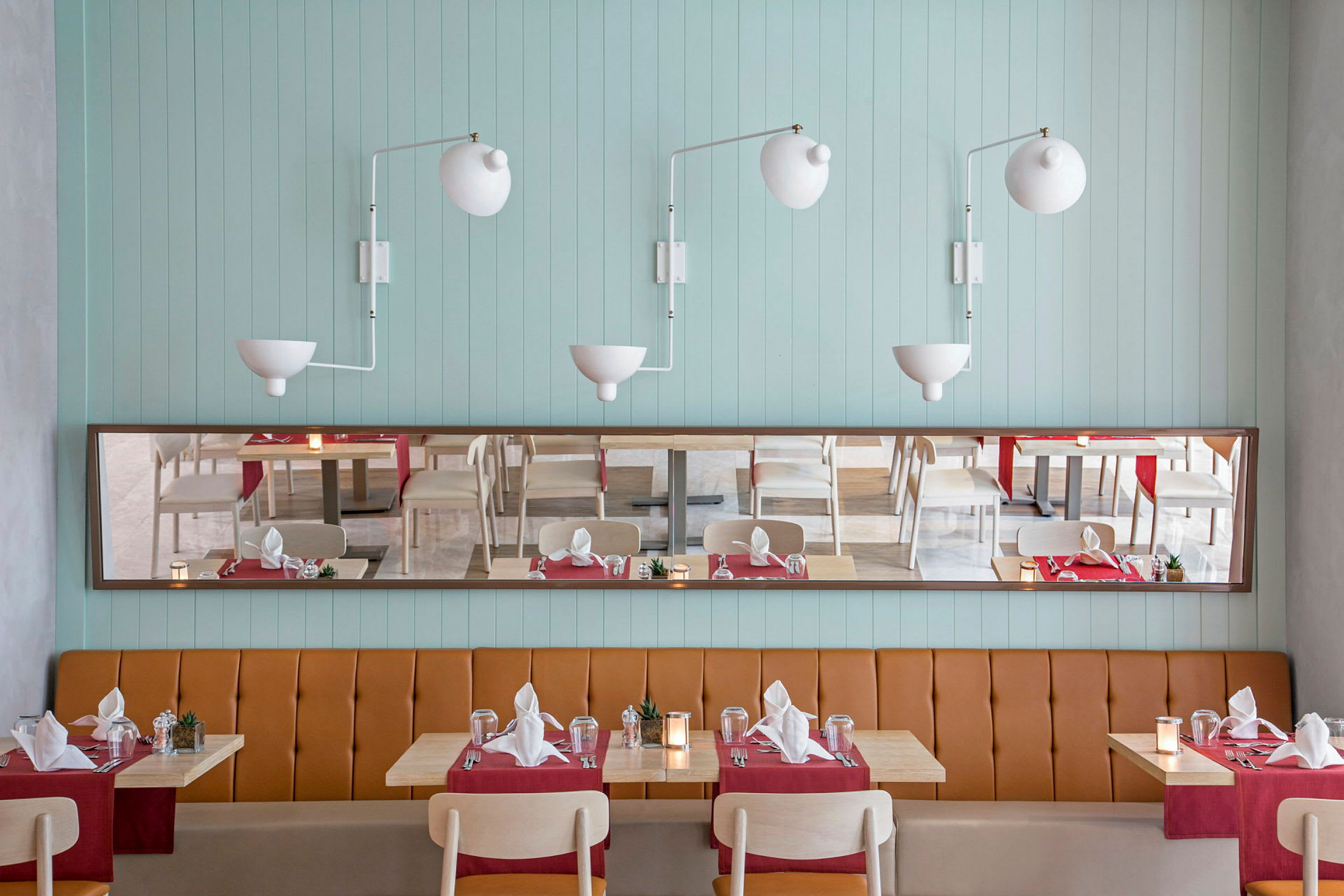 Bilde av en restaurant med dekkede bord, lyseblå vegger og brune sitteplasser. (AI-generert tekst)