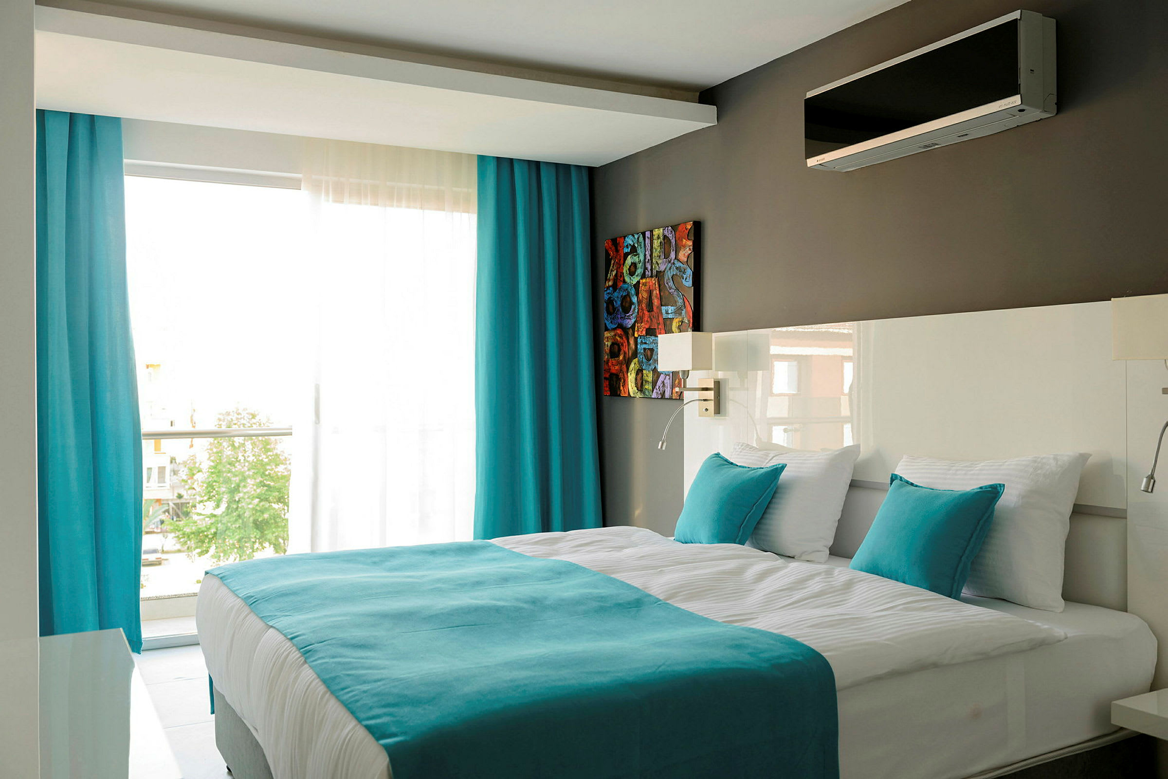 Moderne hotellrom med en dobbeltseng, hvite og turkise farger. (AI-generert tekst)