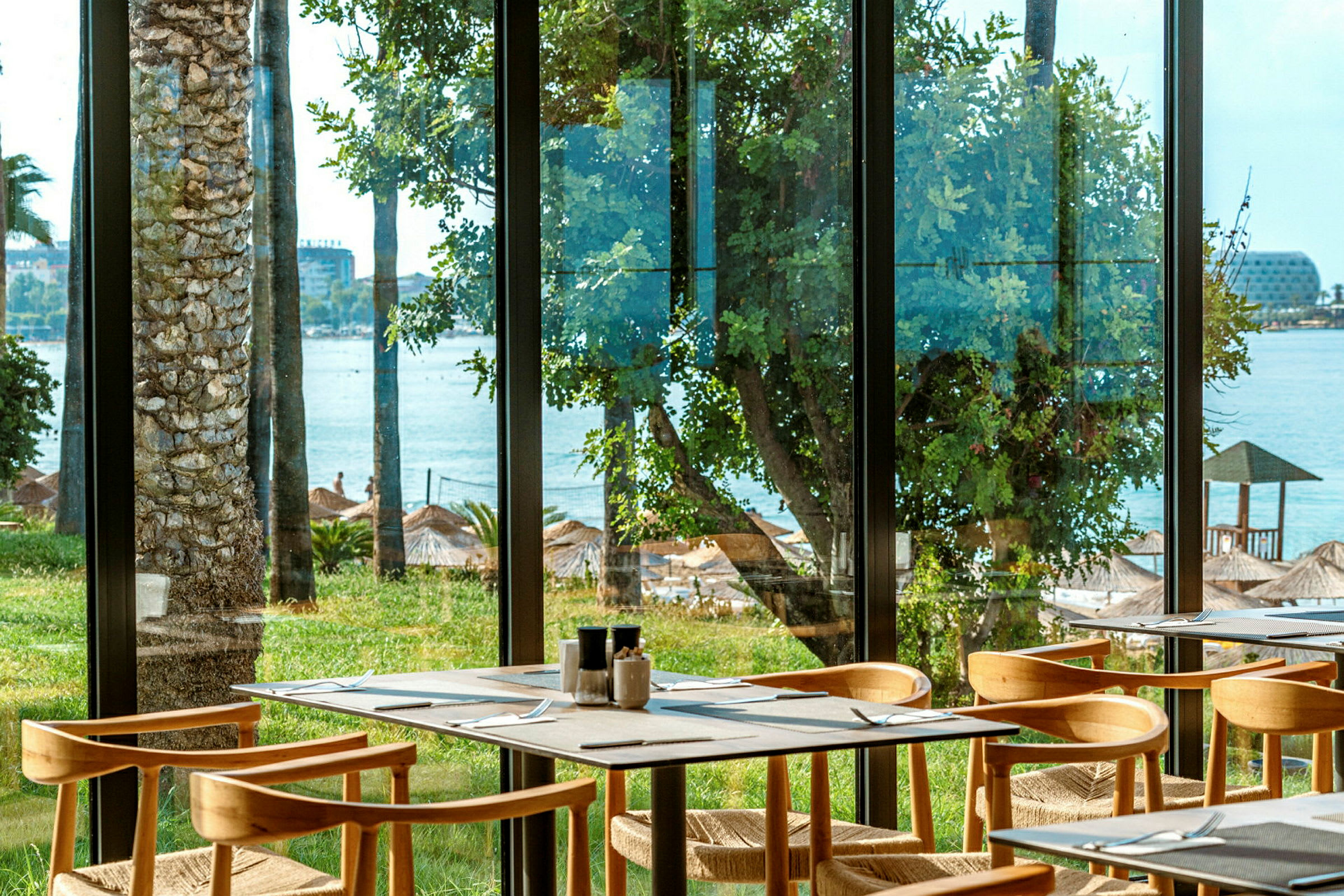 Restaurant med utsikt over stranden gjennom vinduer. (AI-generert tekst)