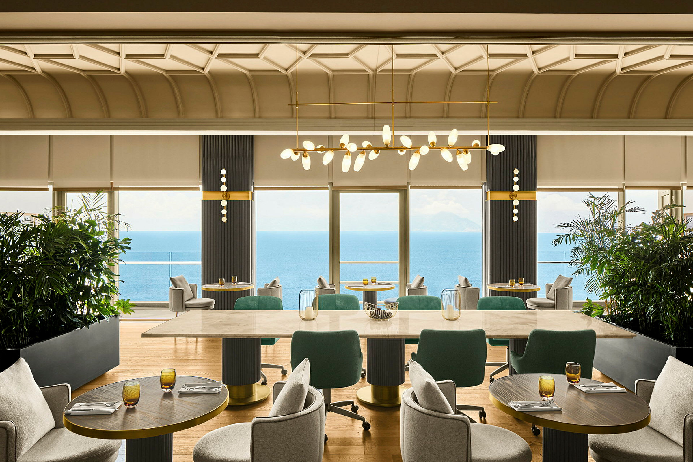 Et godt utstyrt restaurantområde med store vinduer som gir utsikt over havet. (AI-generert tekst)