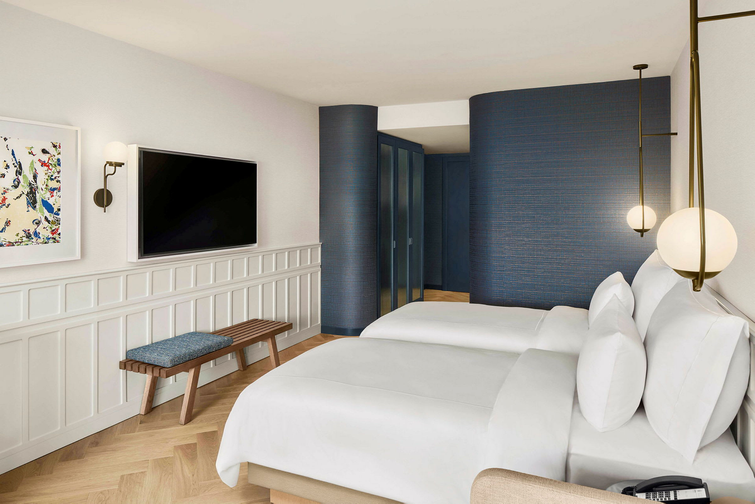 Et hotellrom med to senger, en vegg med en TV og en benk. (AI-generert tekst)