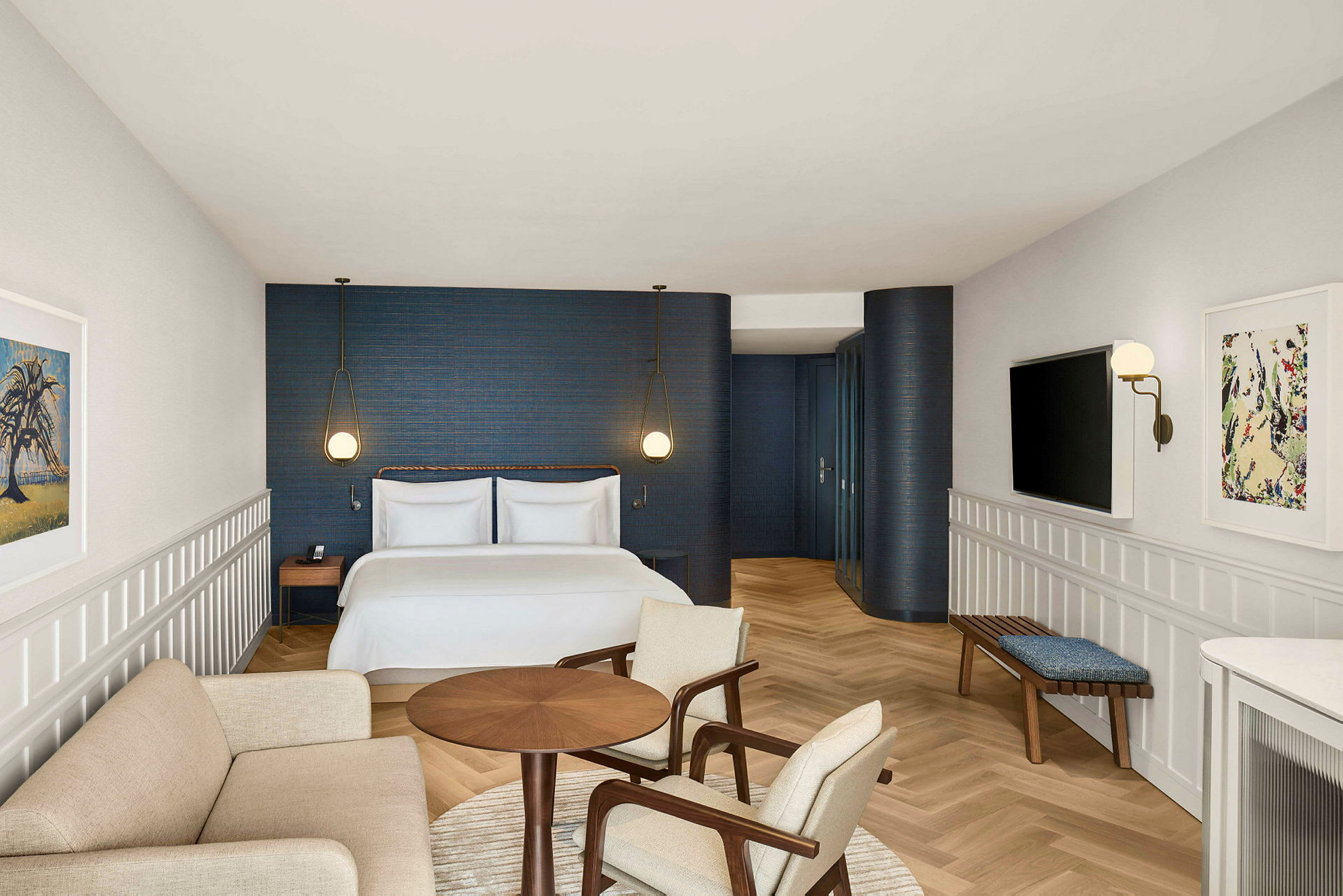 Et hotellrom med en dobbeltseng, en sittegruppe og et moderne design med blå vegger og lyse treinnslag. (AI-generert tekst)