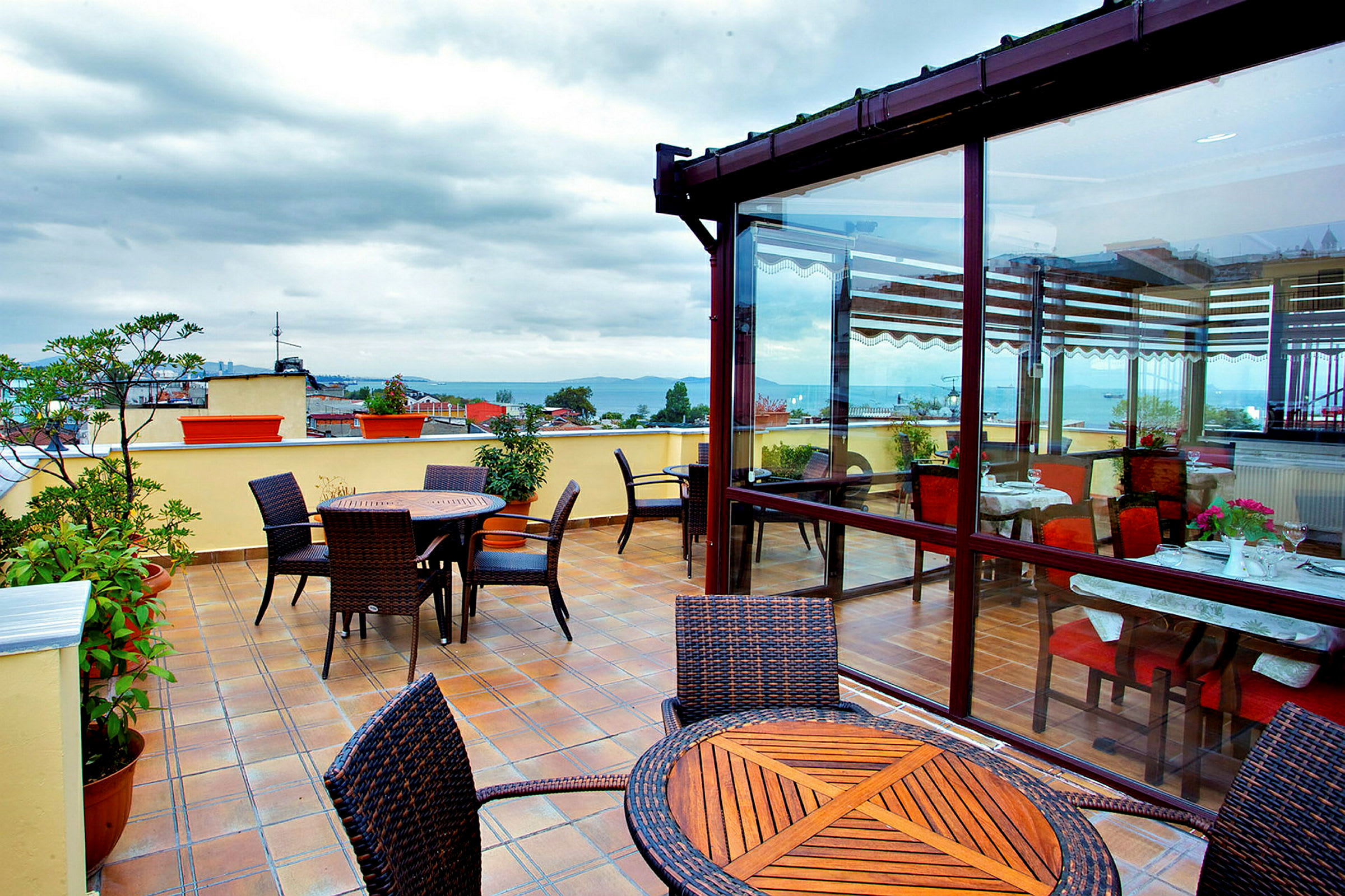 Terrasse med bord og stoler, innendørs og utendørs miljø. (AI-generert tekst)