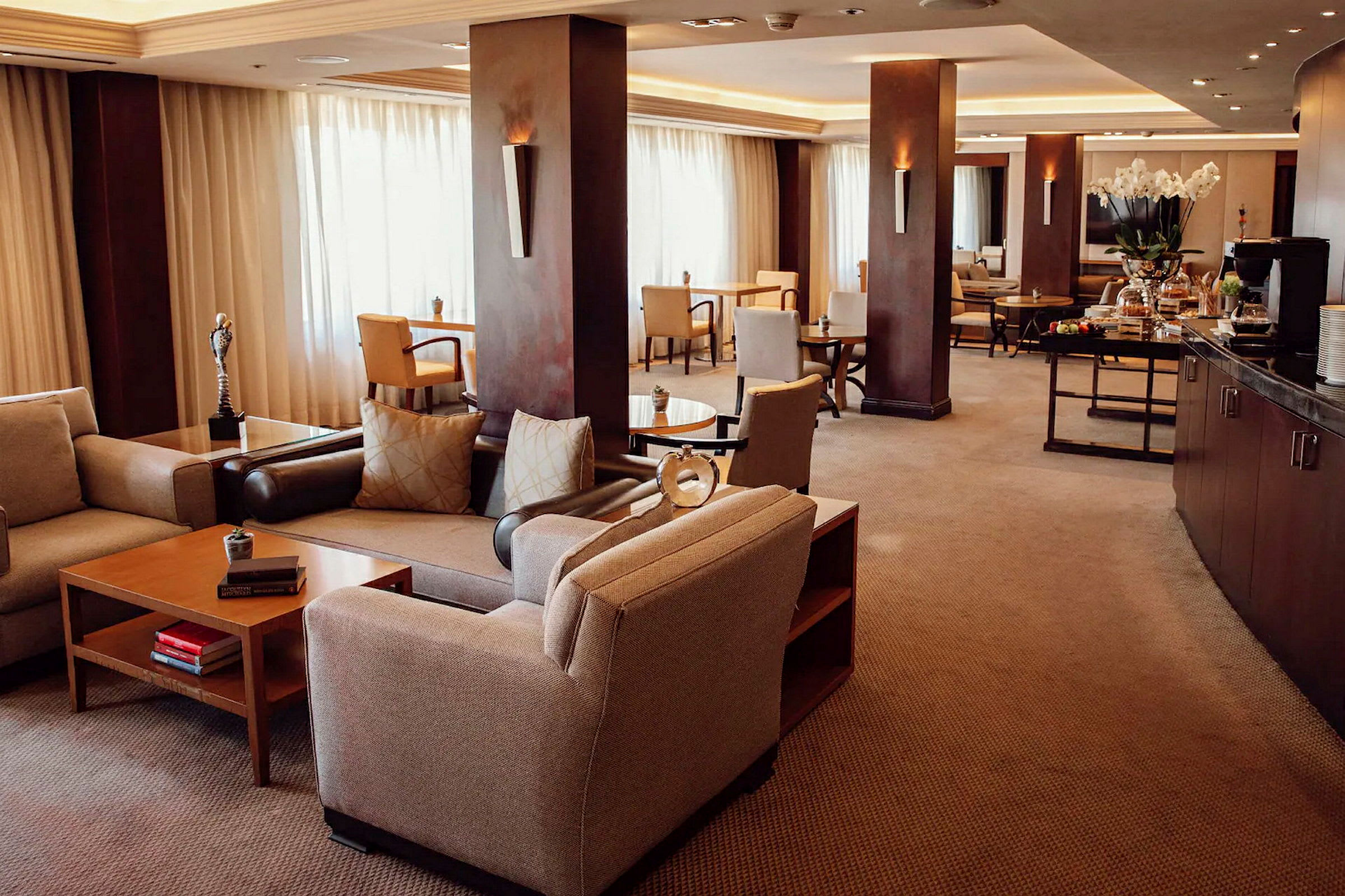 En innbydende hotellounge med komfortable sittemøbler og bord. (AI-generert tekst)