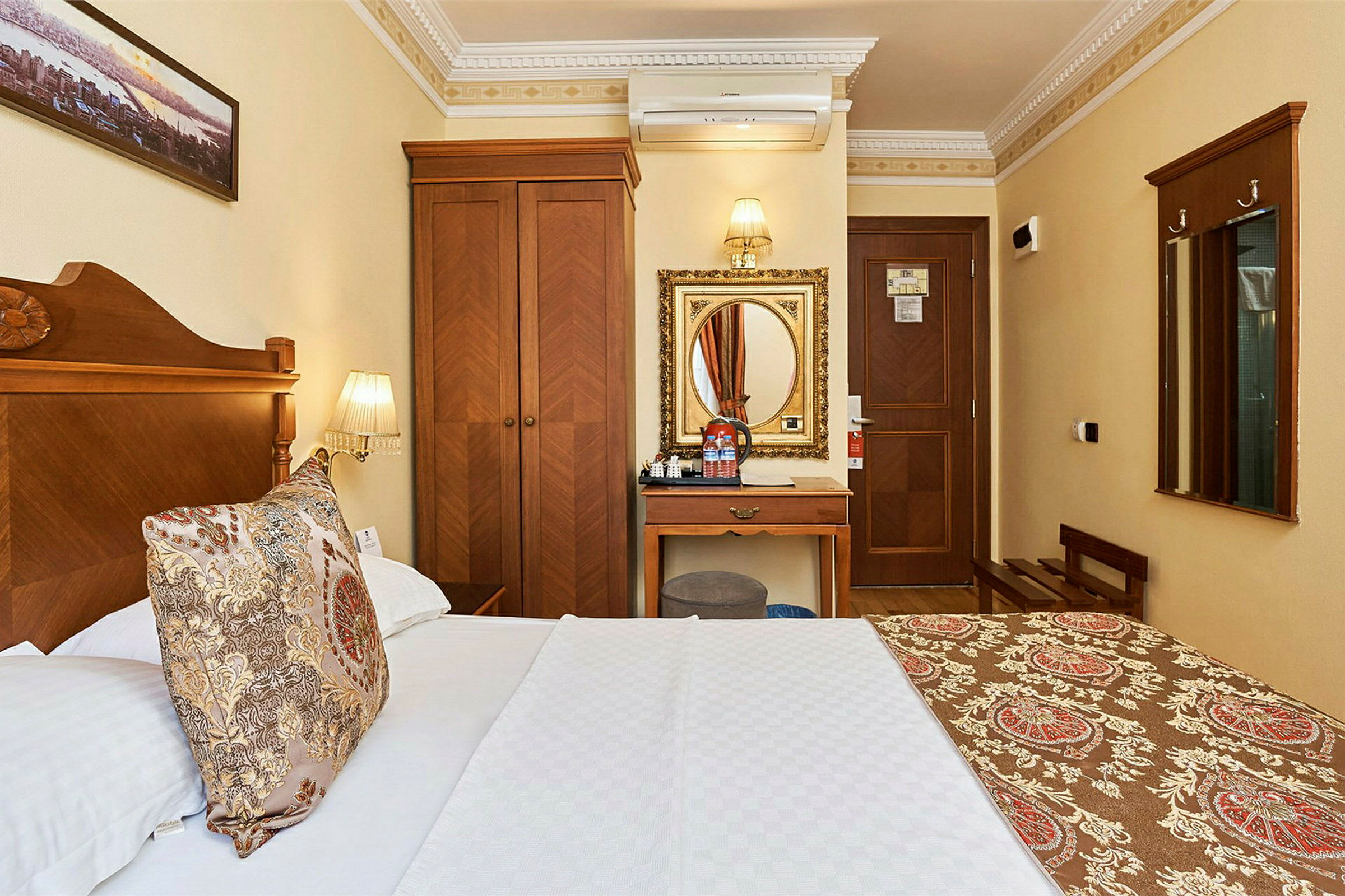 Hotellrom med tremøbler og en seng med et mønstret sengeteppe. (AI-generert tekst)