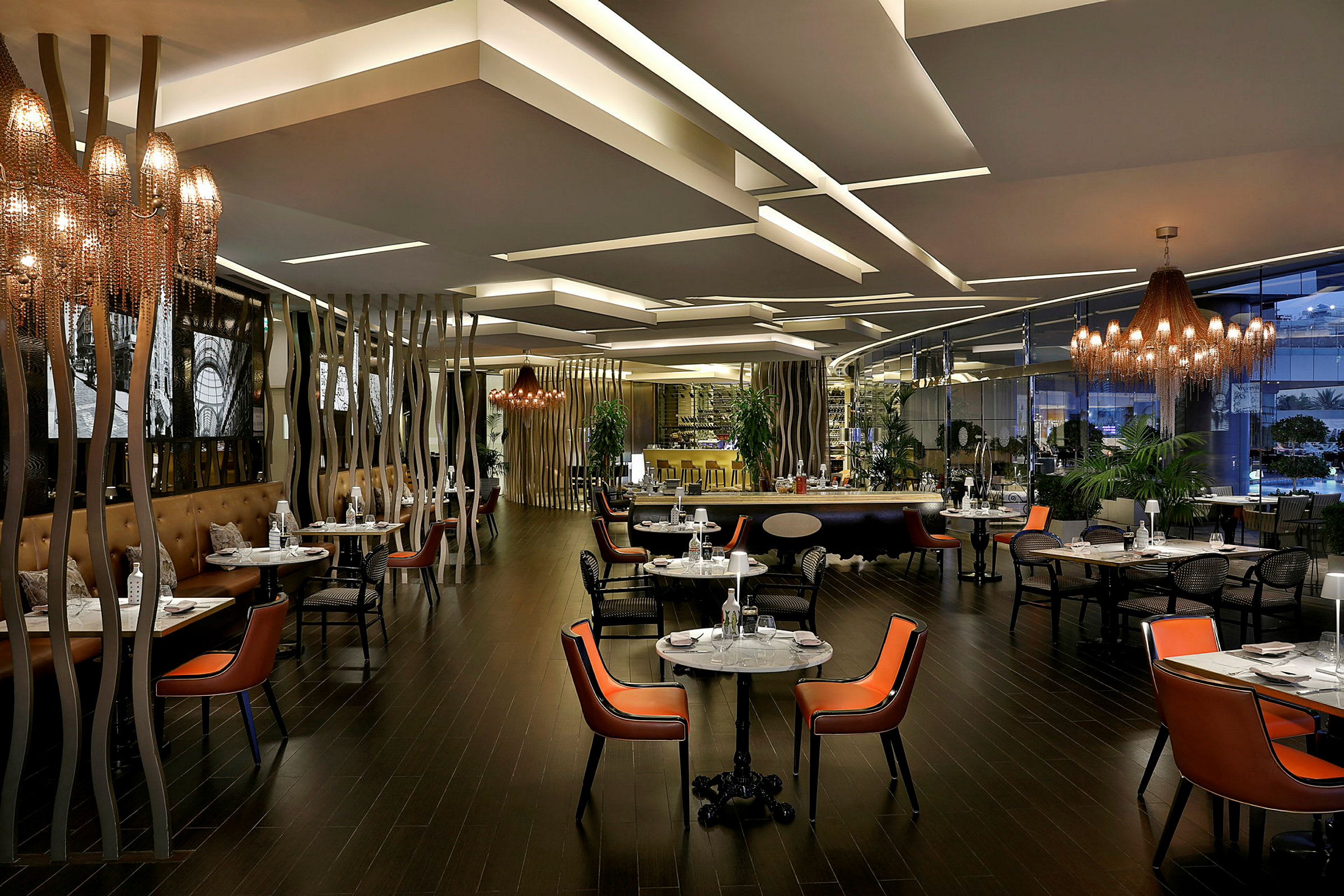 Interiør av en moderne restaurant med belysning, bord og stoler. (AI-generert tekst)