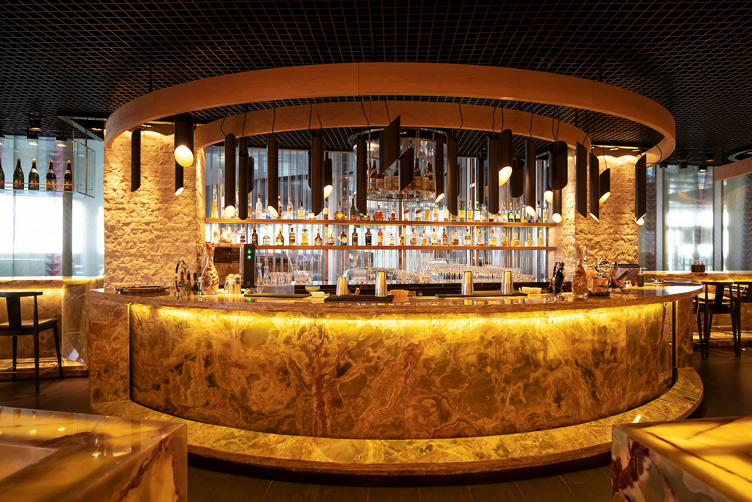 En elegant bar med en buet marmorfront og moderne belysning. (AI-generert tekst)